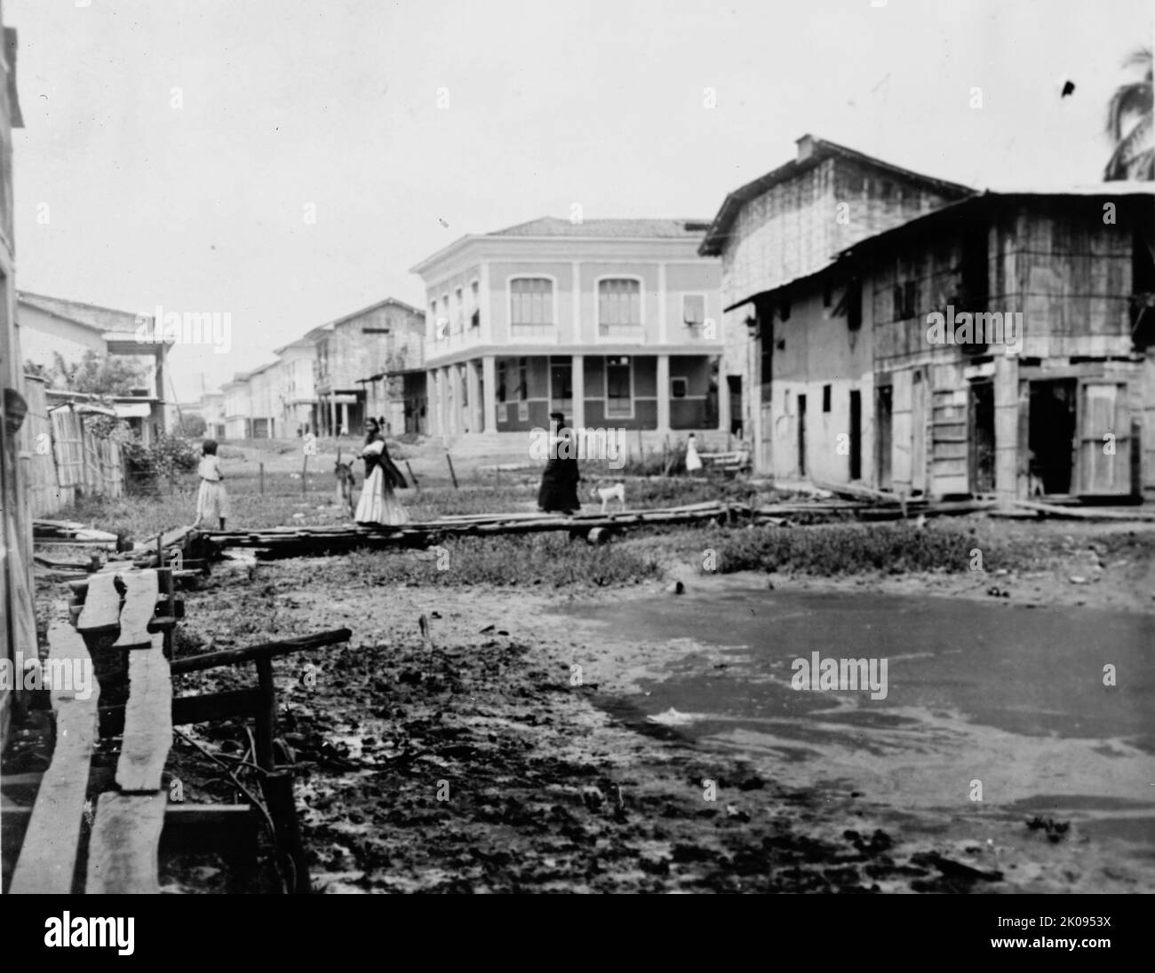 Ecuador - Scenes In Quayaquil [sic], Ecuador, 1912. 'Street scene along the edge of the better part of the city'. Women walking on raised wooden walkway over mud. Stock Photo