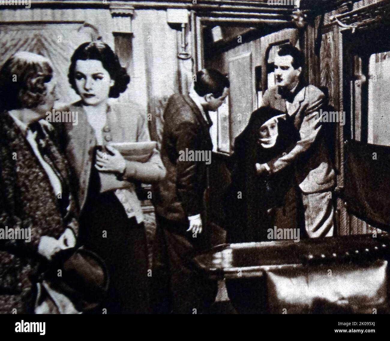 May Whitty, Margaret Lockwood, Naunton Wayne, Catherine Lacey and Michael Redgrave in The Lady Vanishes. The Lady Vanishes is a 1938 British mystery thriller film directed by Alfred Hitchcock. Dame Mary Louise Webster, DBE (nee Whitty; 19 June 1865 - 29 May 1948), known professionally as May Whitty and later, for her charity work, Dame May Whitty, was an English stage and film actress. Margaret Lockwood, CBE (15 September 1916 - 15 July 1990), was an English actress. Naunton Wayne (born Henry Wayne Davies, 22 June 1901 - 17 November 1970), was a Welsh character actor, born in Pontypridd, Glamo Stock Photo