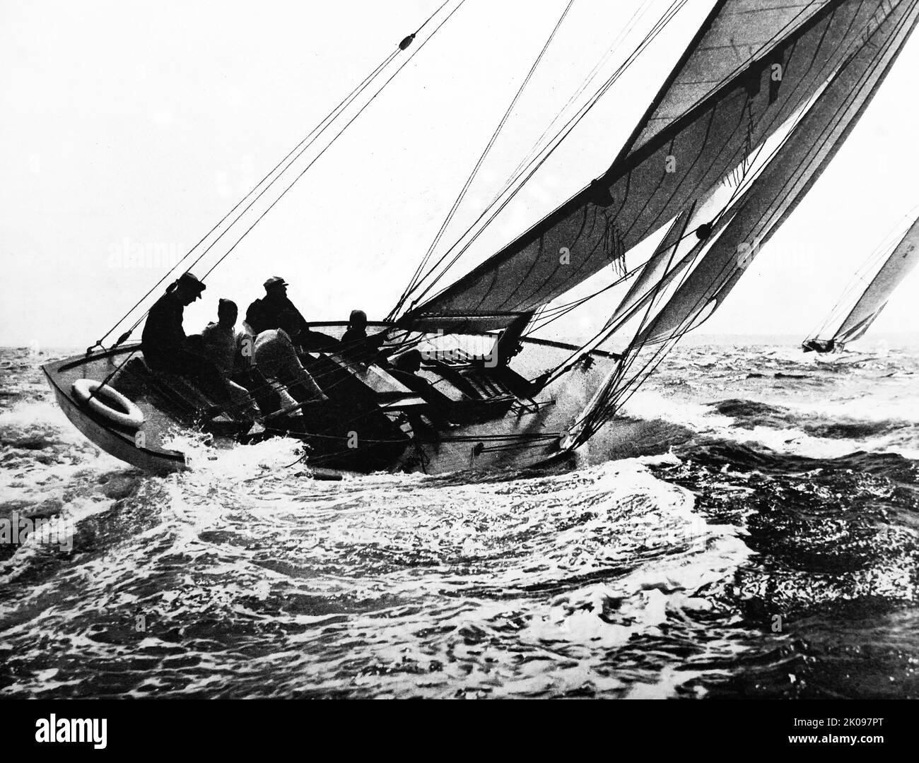 High On The Wind. Black and white photograph of sailing boat and crew. Stock Photo