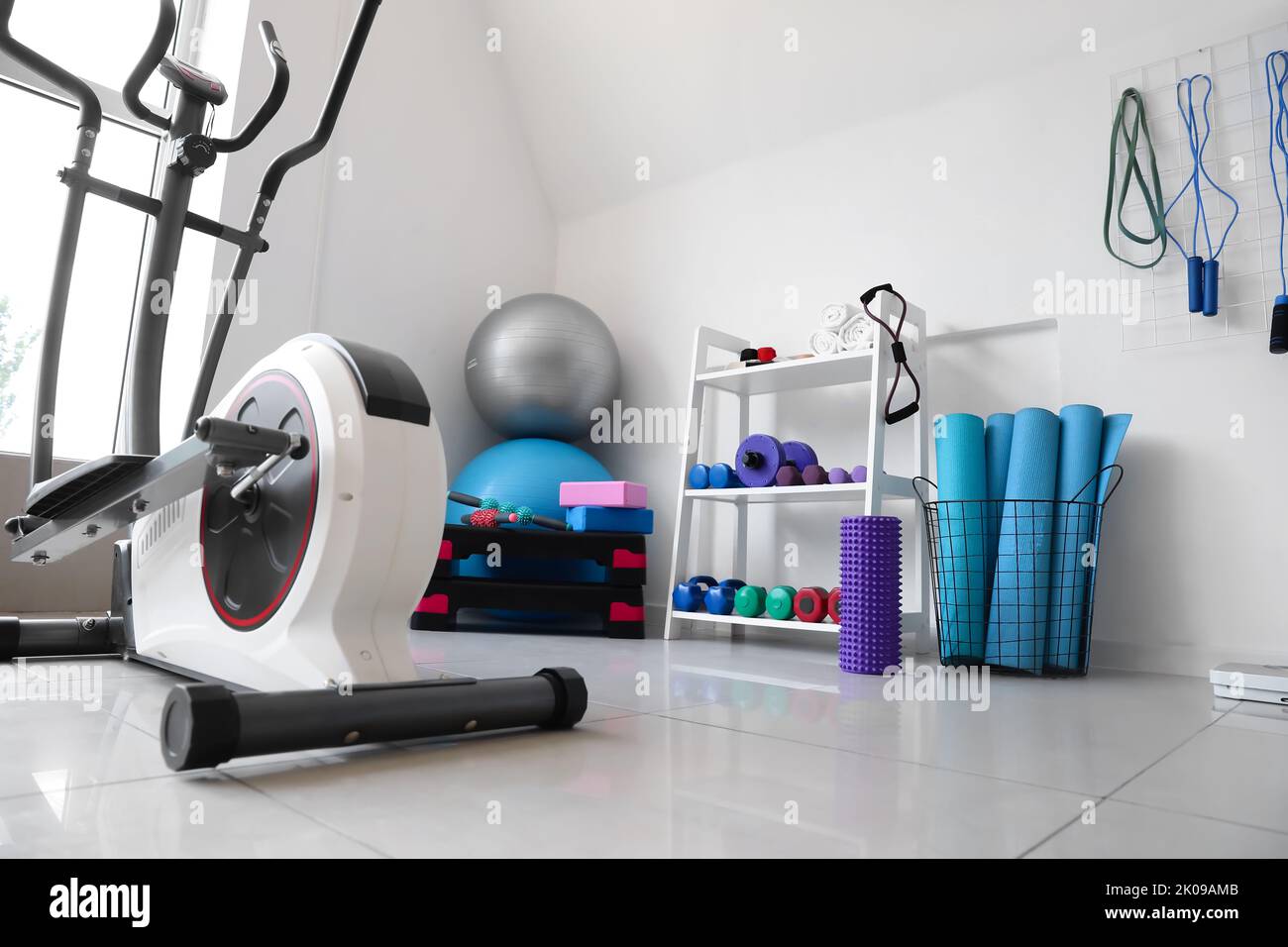 Interior of modern gym with shelving unit and sports equipment Stock