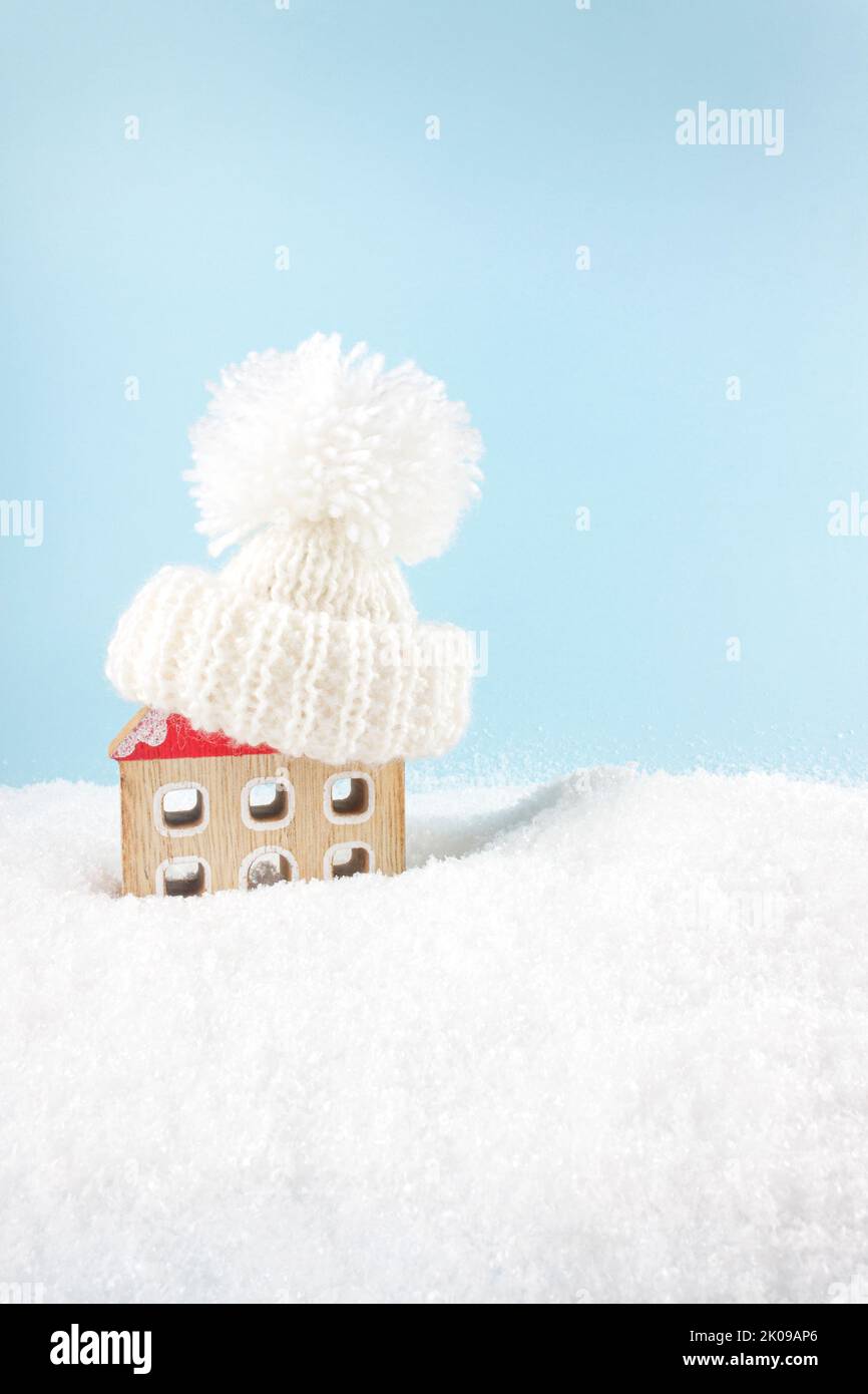Figure of house and warm clothes on the snow background. Heating season concept. European energy crisis concept. Copy space. Stock Photo