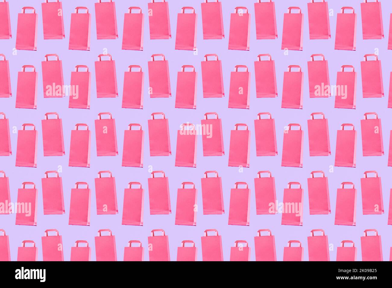 Shopping concept, pastel color pattern, pink trendy paper bags on a lilac background. Stock Photo