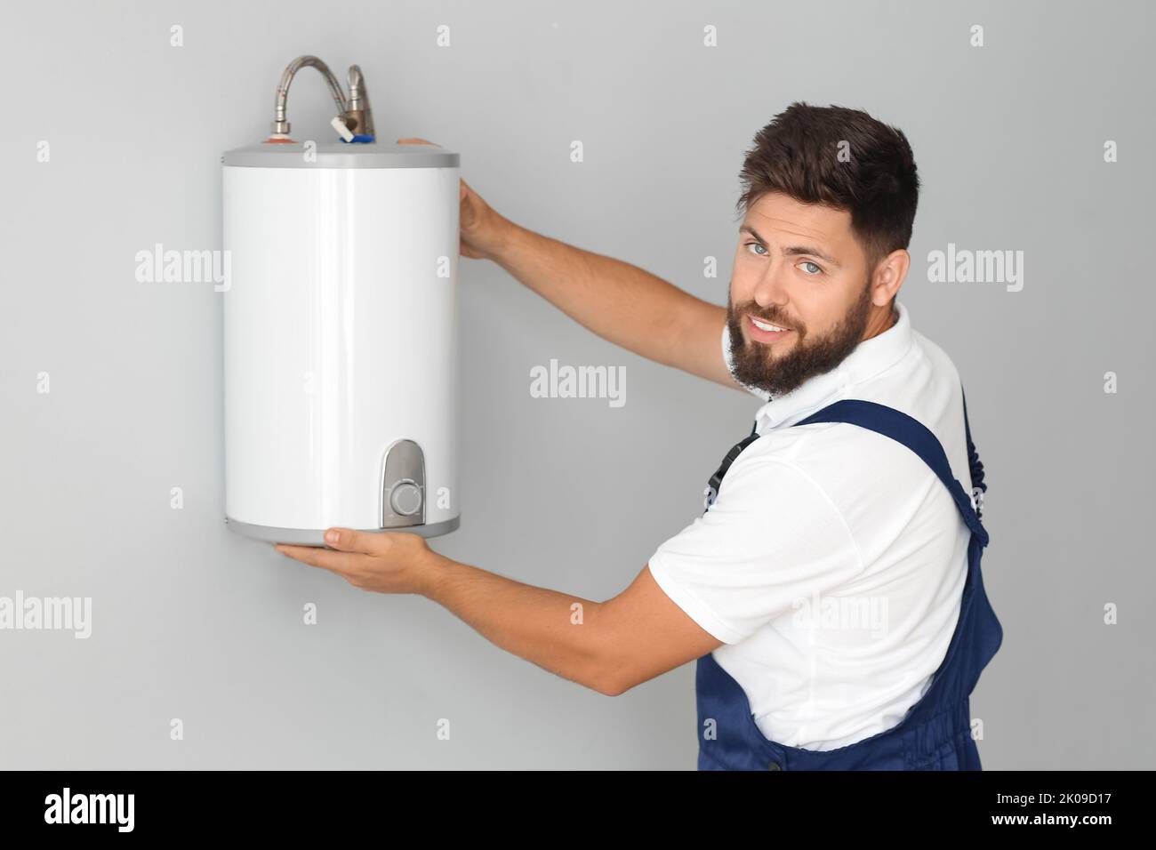 Male plumber installing boiler in bathroom Stock Photo Alamy