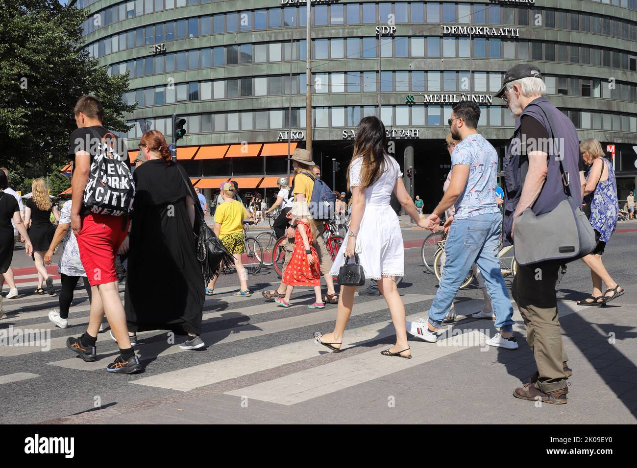Helsinki, Finland - august 20, 2022: Pedestrians using a crosswalk at the Hakaniemi square. Stock Photo