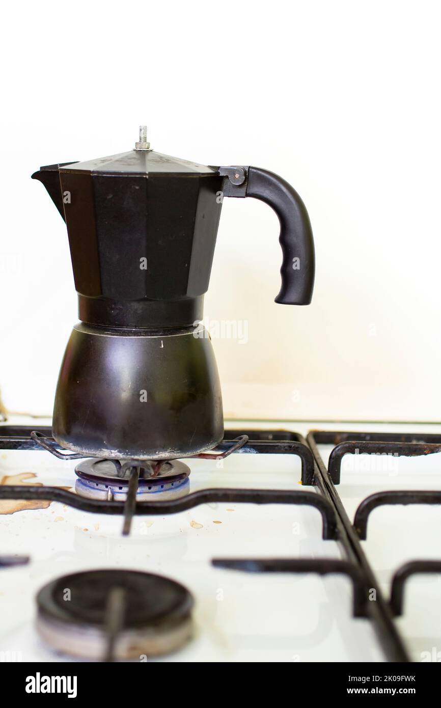 black italian coffee pot on a white burner stove. Stock Photo
