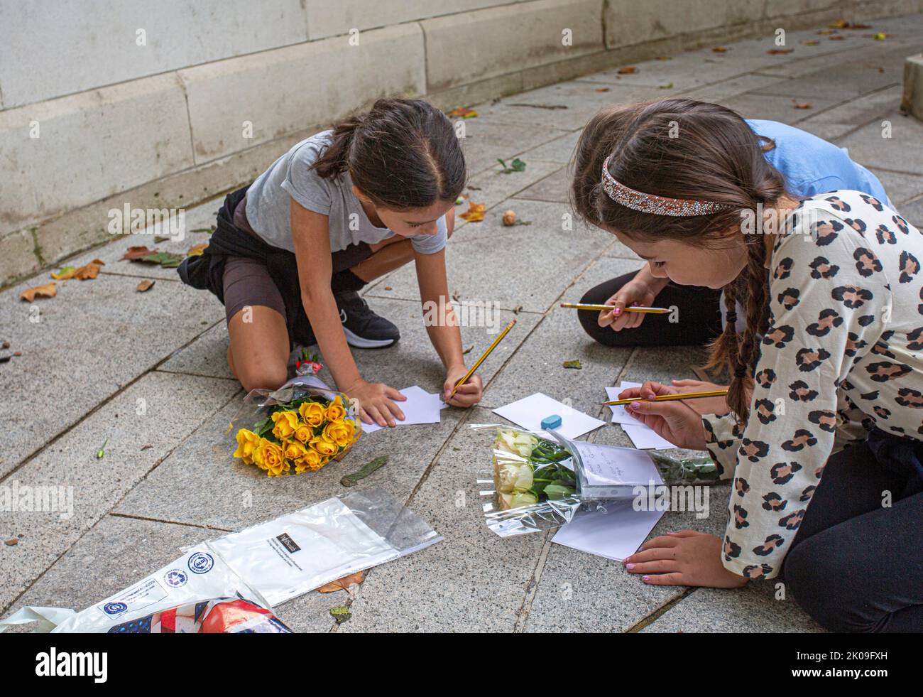 London UK 10th September 2022 - Young girls, writing messages and brining flowers - Mourners gather at Buckingham Palace placing flowers and paying their respects - Queen Elizabeth the second died yesterday in her Platinum Jubillee year at Balmoral Castle. Photo Horst A. Friedrichs Alamy Live News Stock Photo
