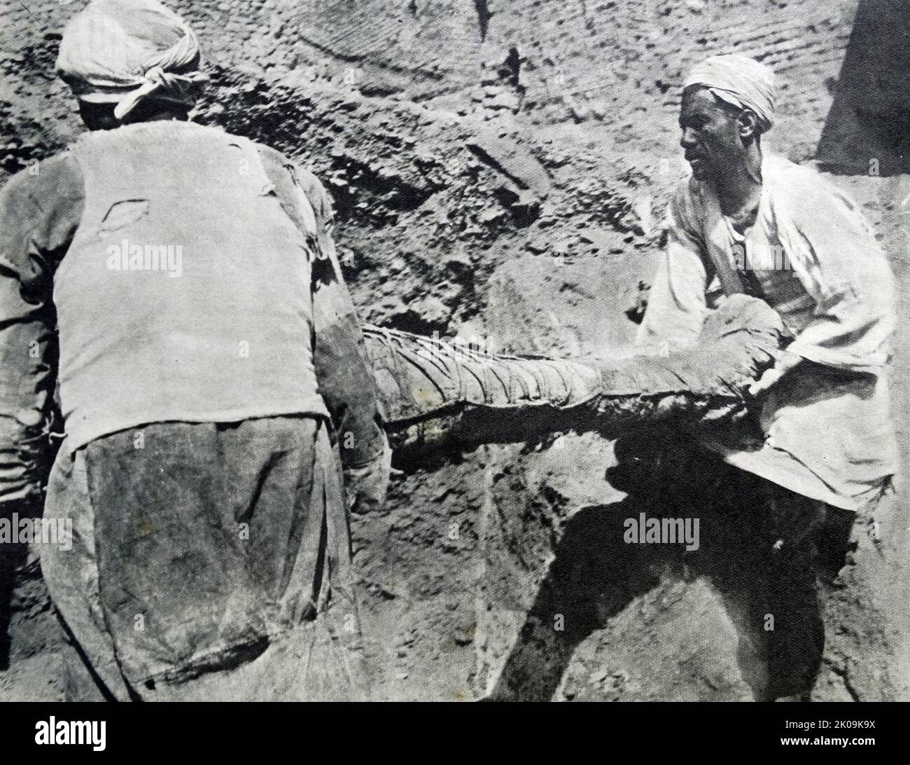 A mummy being removed from a tomb in Egypt. Stock Photo