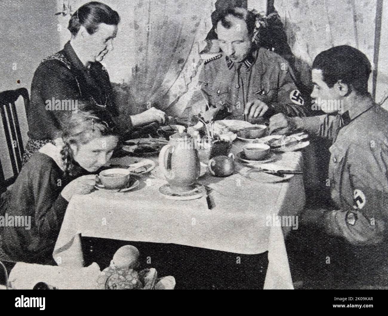 Nazi Storm Trooper Johann Laub eating at home with his family. The Sturmabteilung was the Nazi Party's original paramilitary wing. It played a significant role in Adolf Hitler's rise to power in the 1920s and 1930s. Stock Photo