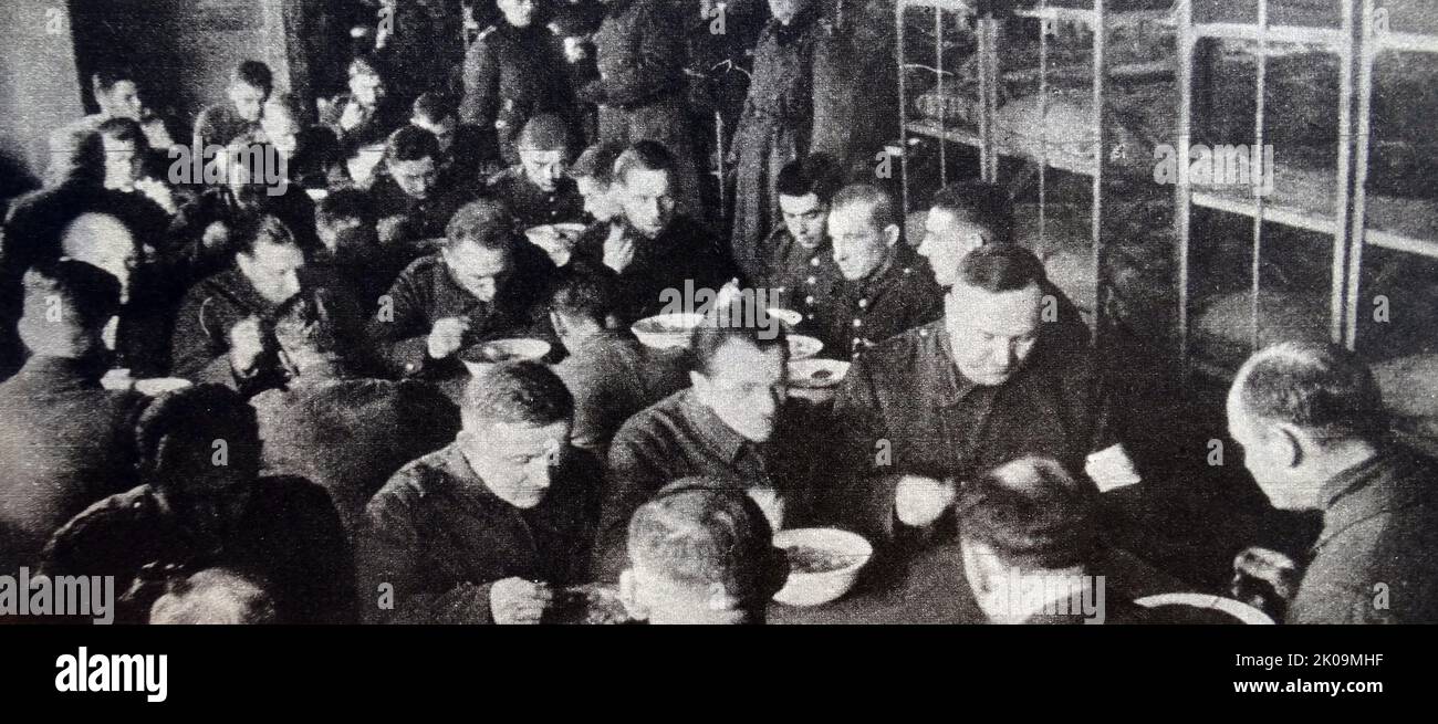 Prisoners are served meals in a German prisoner of war camp during World War II. Official rations are supplemented by parcels sent through the Red Cross. Stock Photo