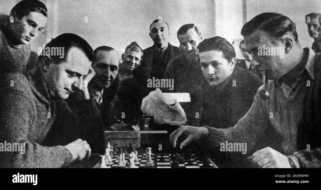 British soldiers playing chess in a Wulzburg German prisoner of war camp during World War II. The Red Cross provided the games and cards. Stock Photo