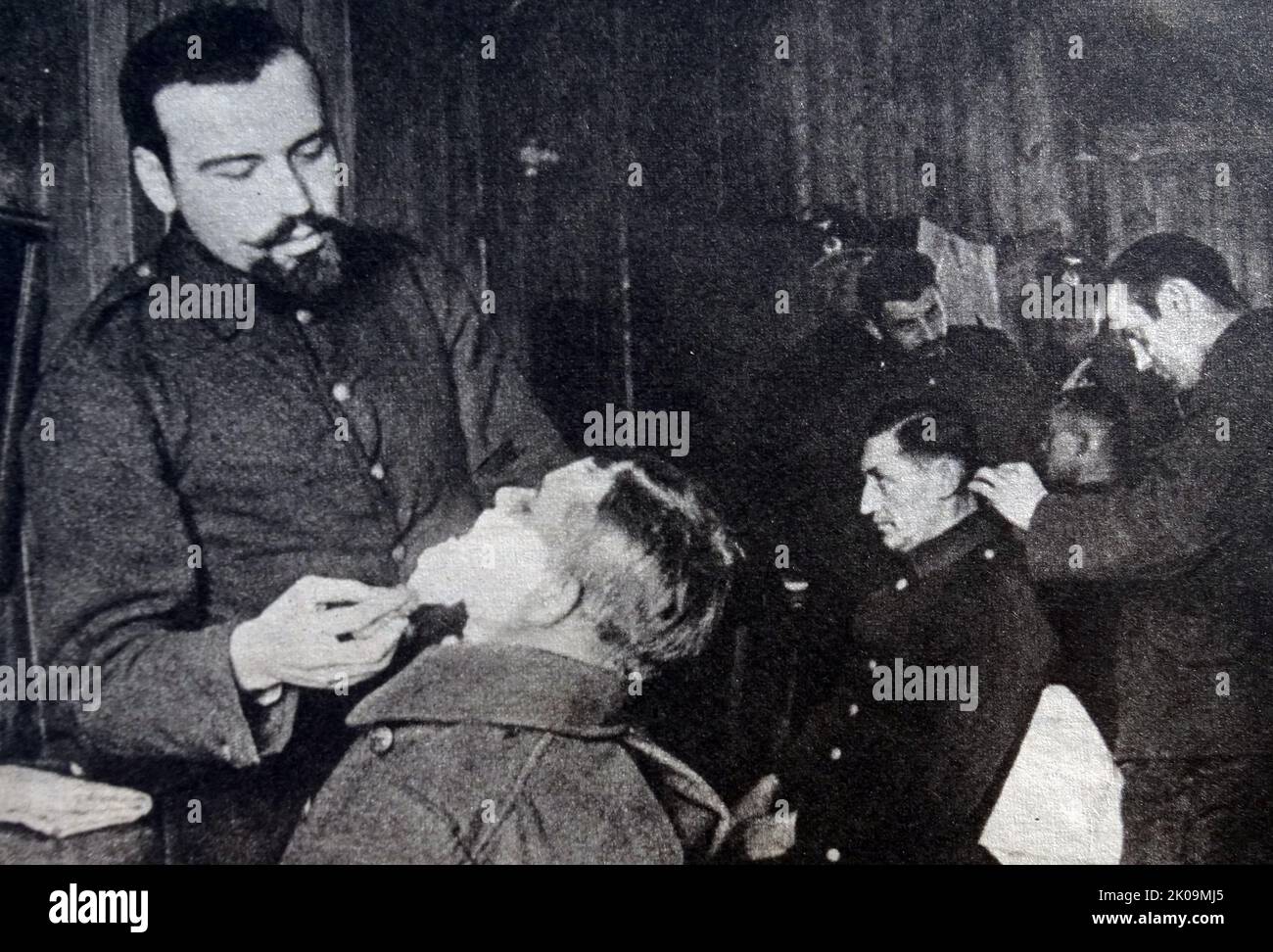 French prisoners tend their comrades in Wulzburg prisoner of war camp during World War II, where they set up a barbers shop. Stock Photo