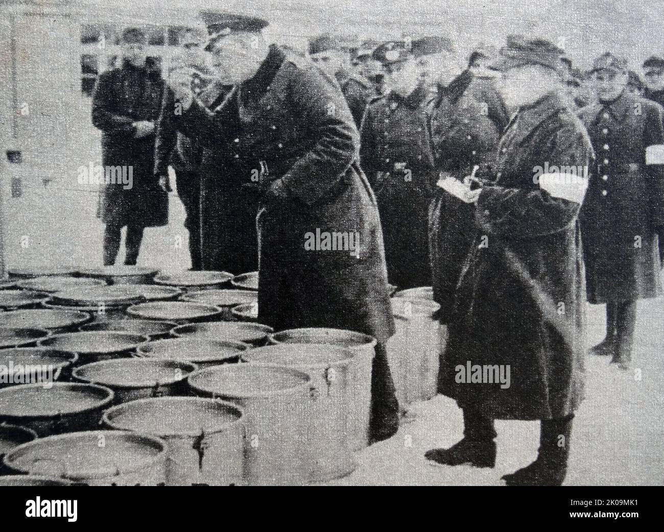 A German officer on duty in Wulzburg prisoner of war camp during World War II, samples the soup before it is served. According to the Red Cross Convention, prisoners should receive the same food as guards. Stock Photo