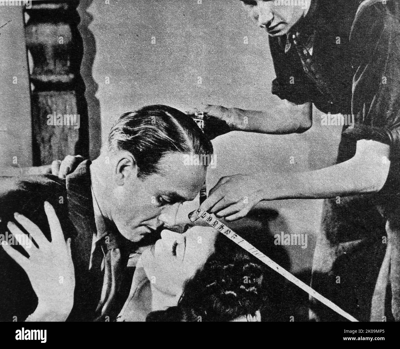 Screen kiss between two actors captured on camera in a 1940s film. Stock Photo