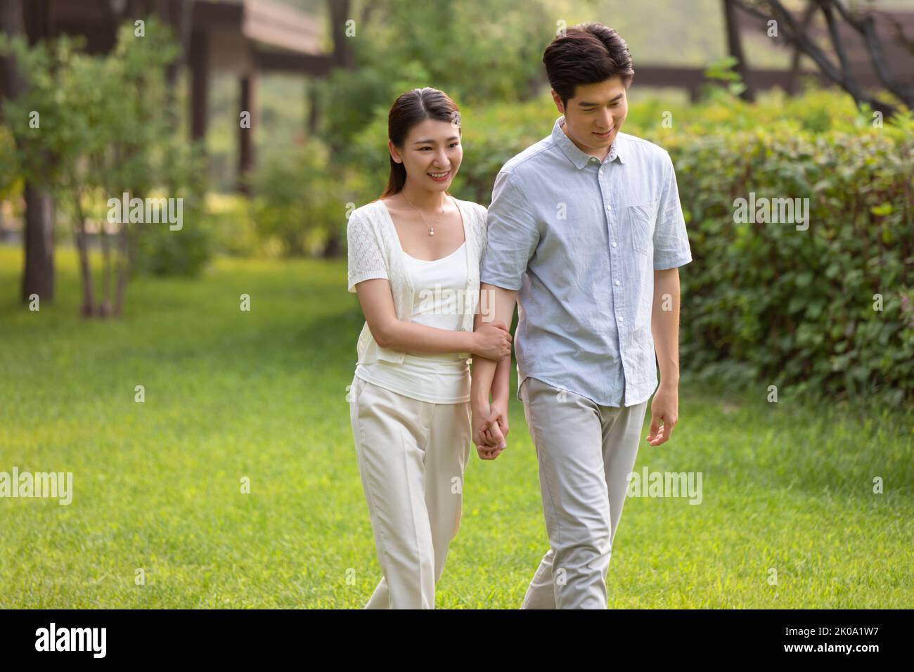 Happy young Chinese couple relaxing in park Stock Photo - Alamy