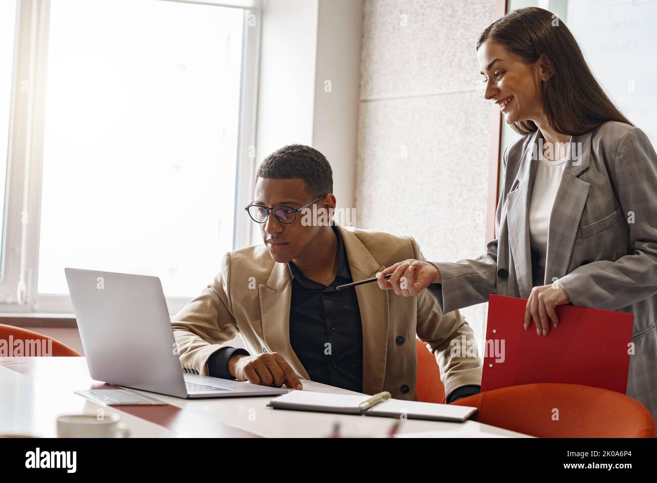 Businesspeople working together in modern coworking, sitting at desk Stock Photo