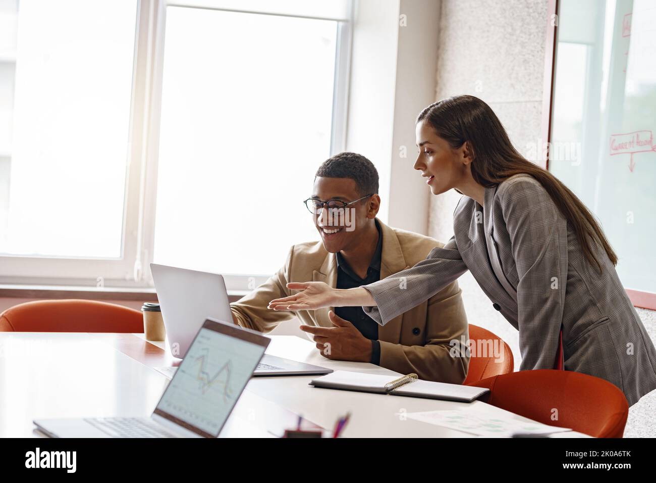 Businesspeople working together in modern coworking, sitting at desk Stock Photo