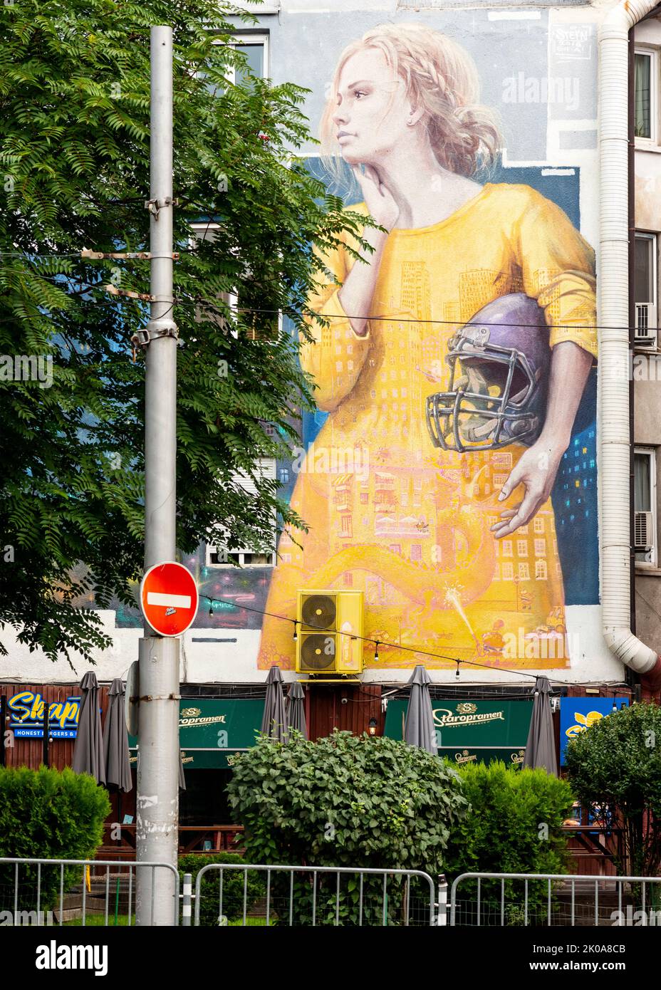 Mural depicting young woman holding an American football helmet in Sofia, Bulgaria, Eastern Europe, Balkans, EU Stock Photo