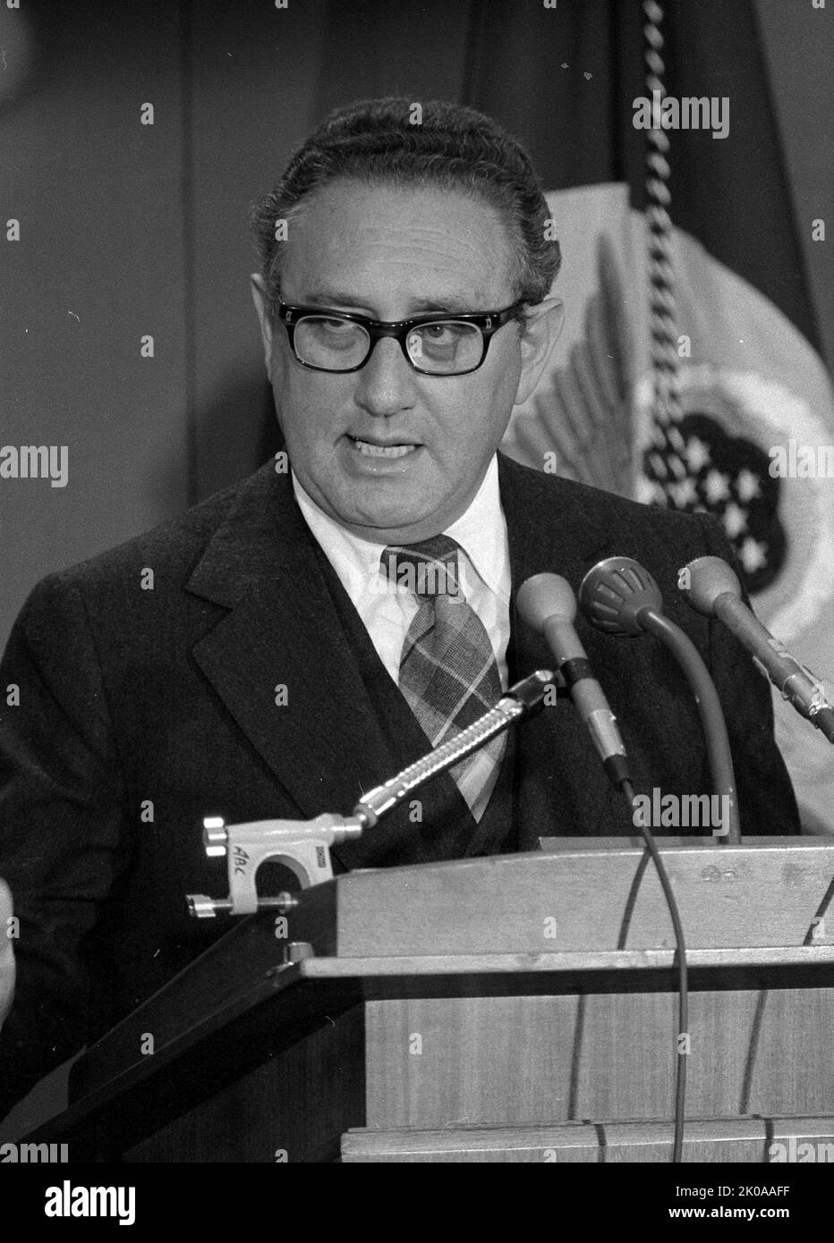U.S. Secretary of State Henry Kissinger, half-length portrait, standing behind a podium, speaking at a press conference. 1975. Henry Alfred Kissinger KCMG (May 27, 1923) is a German-born American politician, diplomat, and geopolitical consultant who served as United States Secretary of State and National Security Advisor under the presidential administrations of Richard Nixon and Gerald Ford Stock Photo