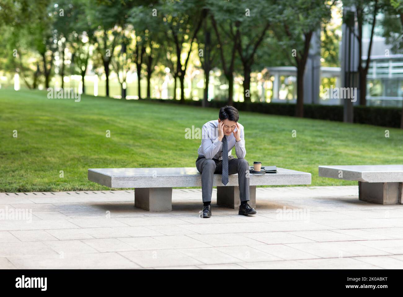 Young Chinese businessman having a headache Stock Photo