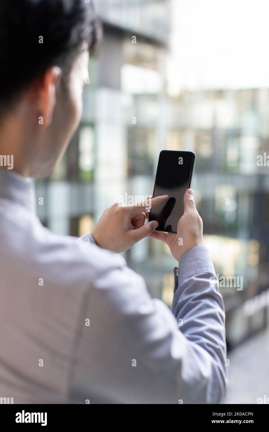 Young Chinese businessman using smart phone Stock Photo