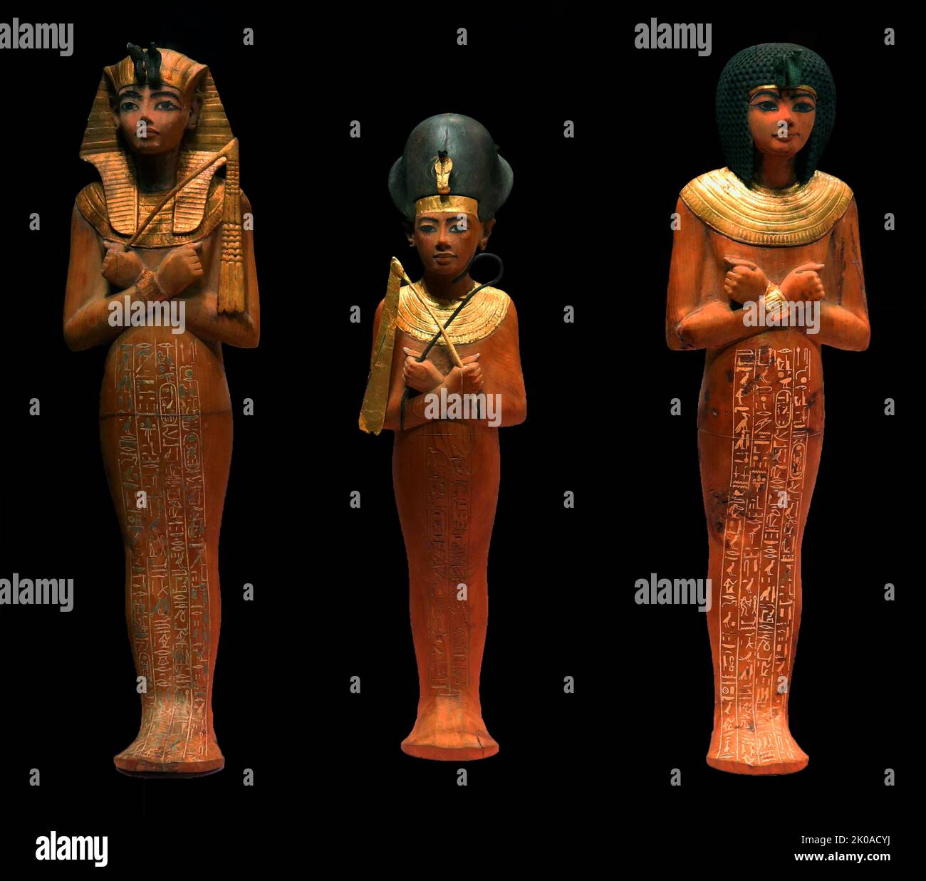 Ancient Egyptian, gilded wood, funerary figurines. Left to right: King Tutankhamun wearing a Nubian wig, King Tutankhamun wearing the blue crown (Khepresh); King Tutankhamun wearing the 'Nemes' Headdress. 1326 BC. Tomb relics from the king's tomb Stock Photo