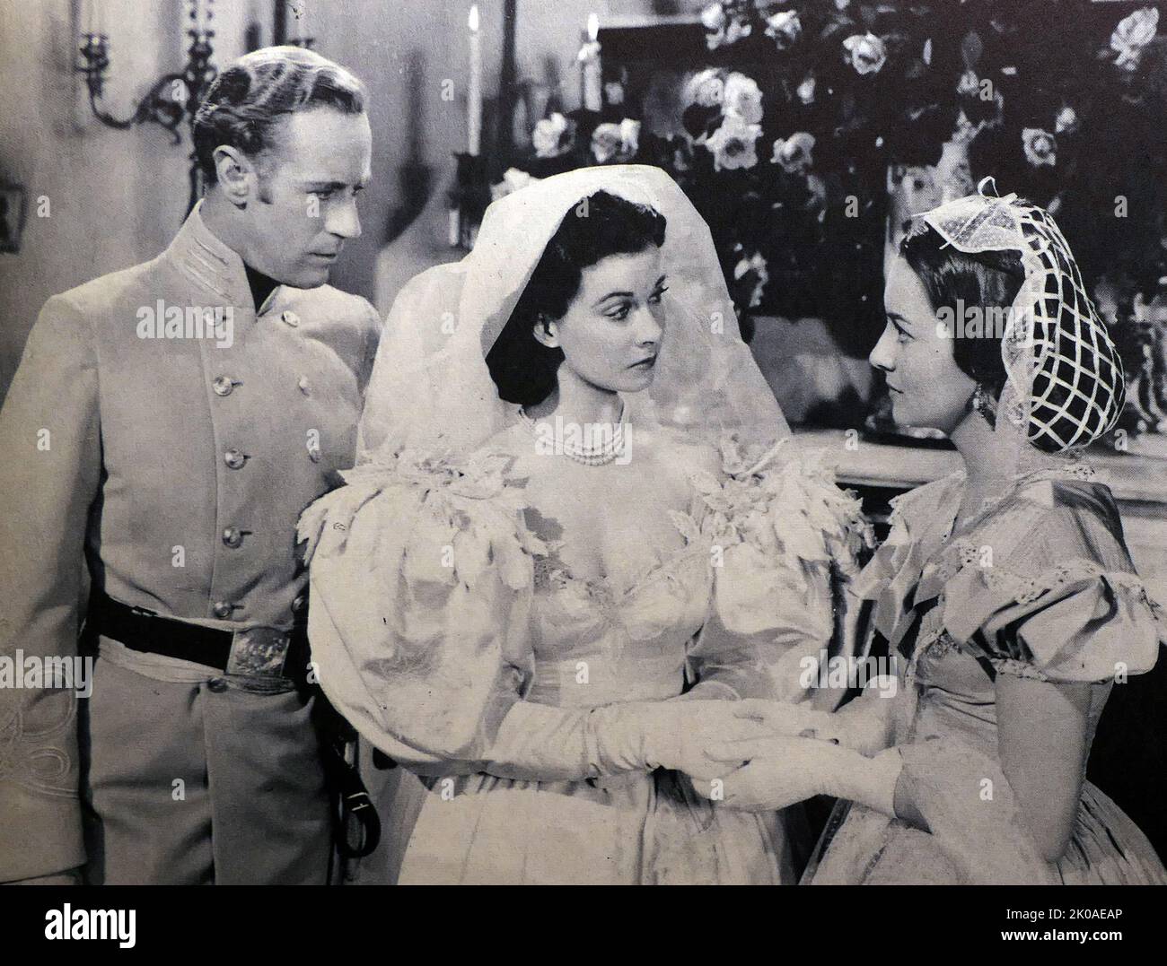 Leslie Howard, Vivien Leigh and Olivia de Havilland in Gone with the Wind, a 1939 American epic historical romance film, adapted from the 1936 novel by Margaret Mitchell. The film was produced by David O. Selznick of Selznick International Pictures and directed by Victor Fleming, and was set in the American South against the backdrop of the American Civil War and the Reconstruction era Stock Photo