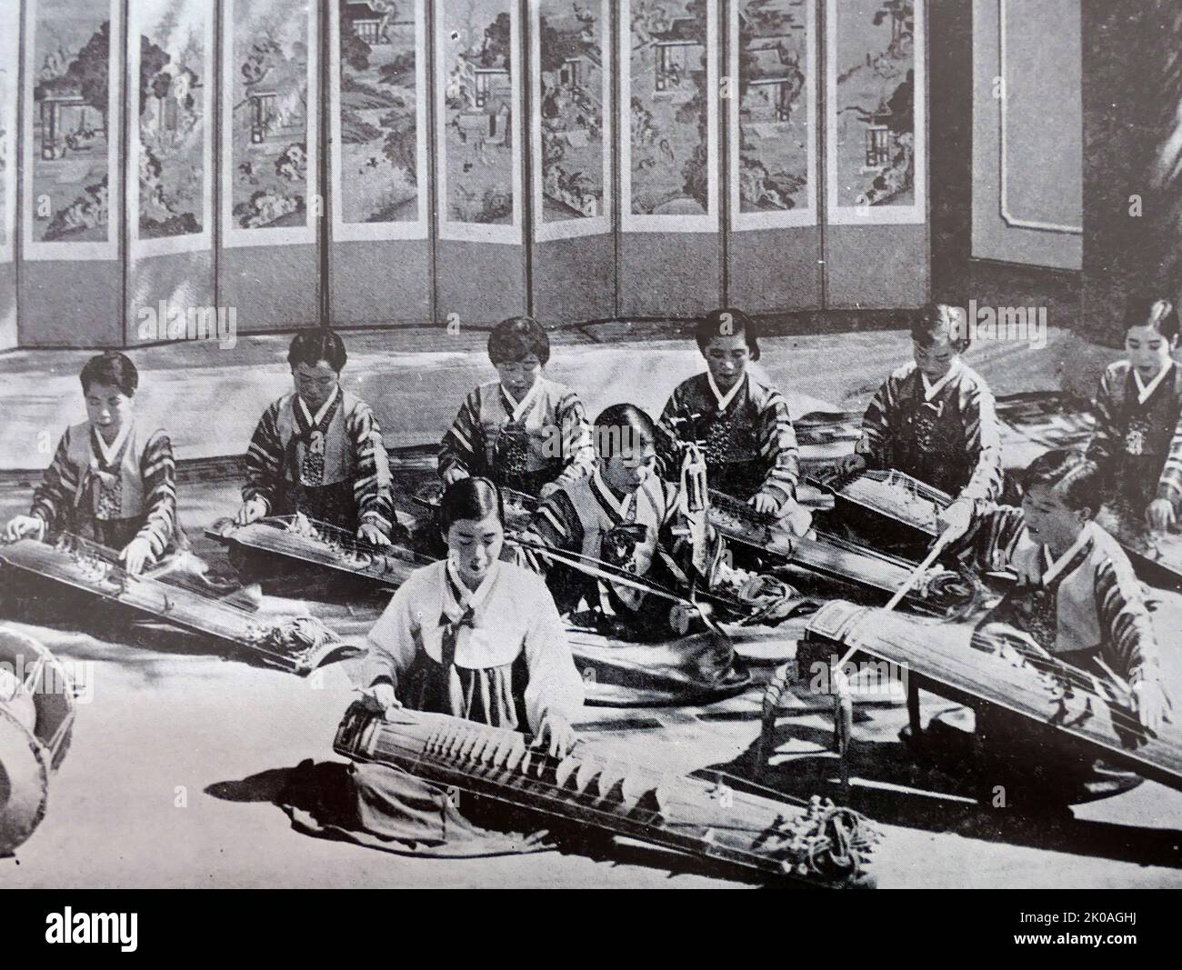 The musicians shown here are all college students. The instruments in the back row are all Gayageum : a plucked zither with 12 strings, though some more recent variants have 18, 21 or 25 strings. It is probably the best known traditional Korean musical instrument. The front row, from left to right, we see a Janggu (drum), Geomungo (plucked zither with both bridges and frets, made in Goguryeo before the 5th century AD) and an A-jaeng (string, plays the bass part in ensemble music). In the middle, she is playing a Haegeum (string). Stock Photo