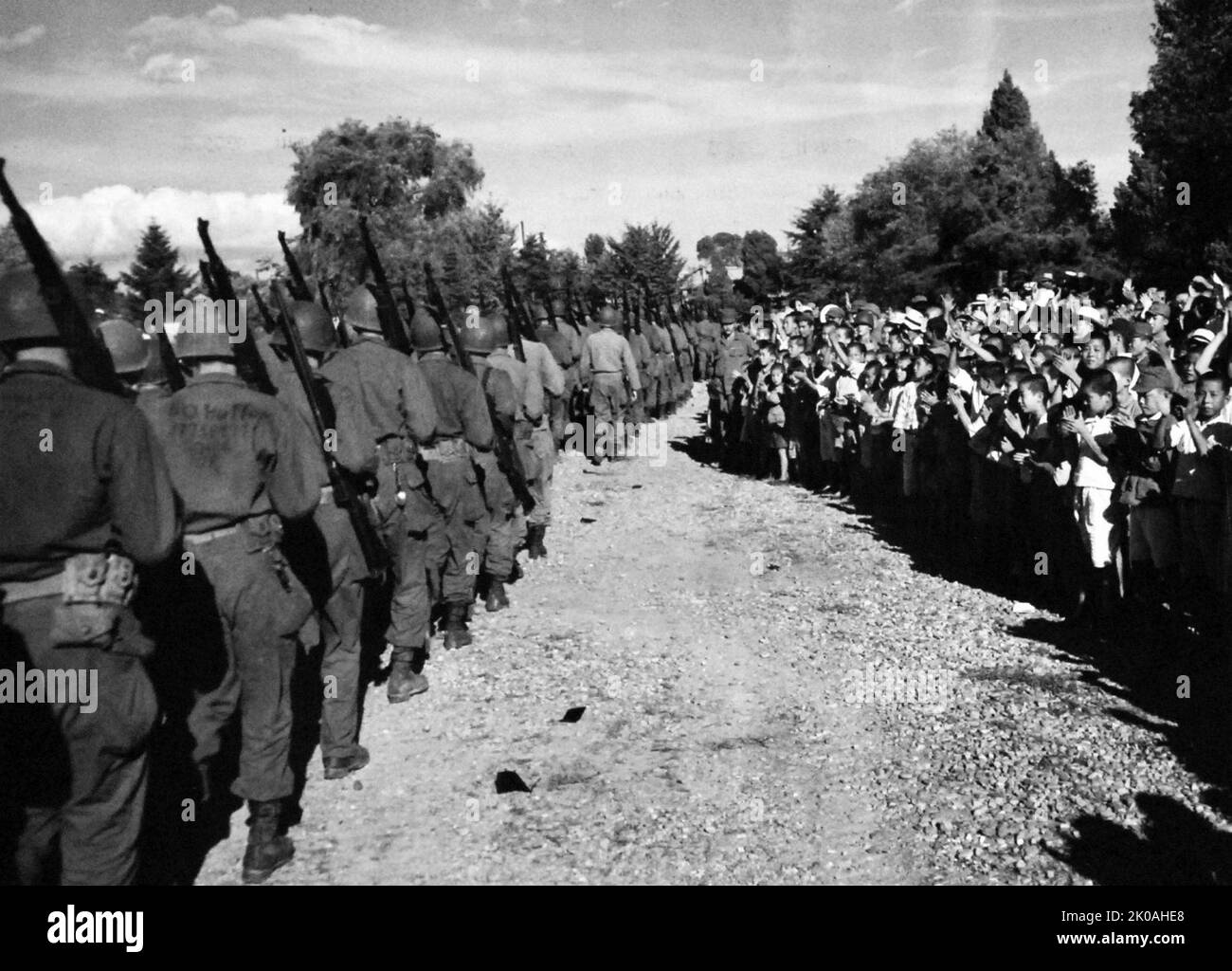 Surrender of Japanese Forces, September 9, 1945. Korean children cheering US occupation troops following the hauling down of Japanese flag at Keijo (Seoul), Korea. Stock Photo