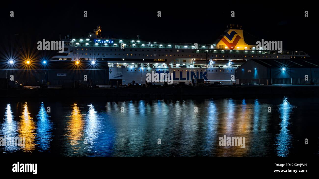 Tallink MS Victoria ferry ship moored in Leith harbour to accommodate Ukrainian refugees lit up at ngiht with reflections, Edinburgh, Scotland, UK Stock Photo