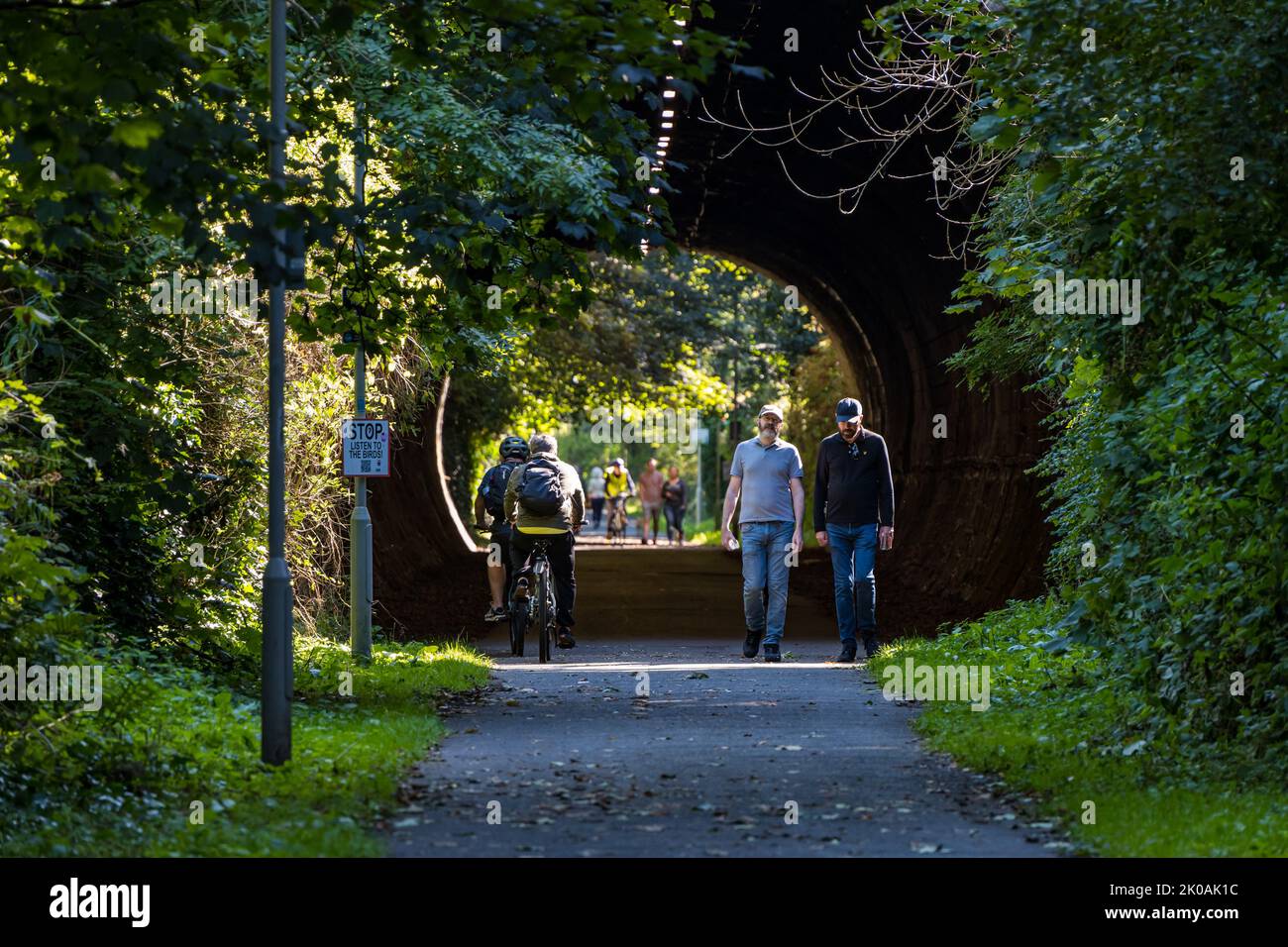 People walking and cyclists riding bikes through tunnel on railway path, Edinburgh, Scotland, UK Stock Photo