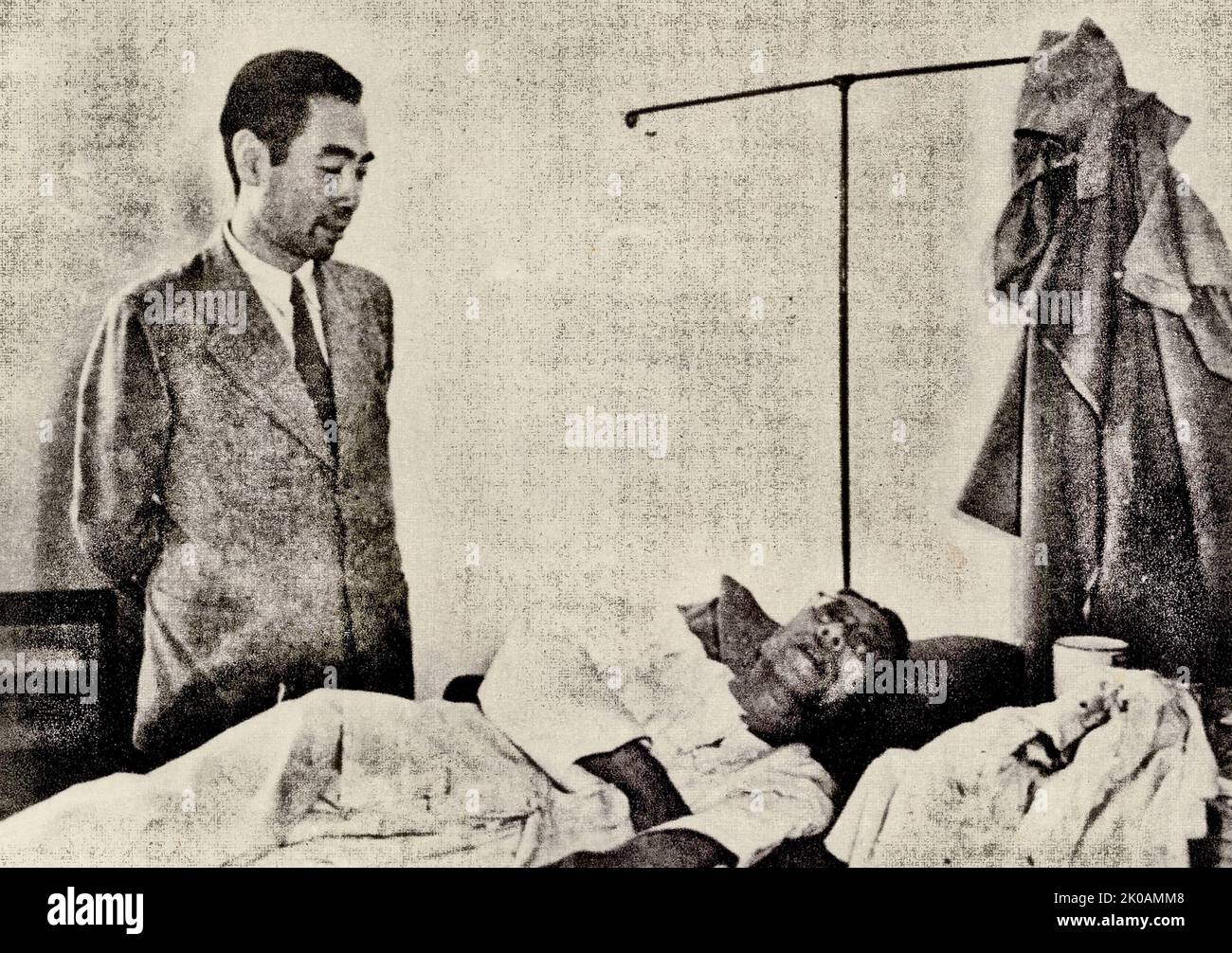 Zhou Enlai condolences to injured representatives at the hospital. Pictured is Zhou Enlai in front of Ma Xulun's bed. Ma was a Chinese politician, activist, and linguist. Stock Photo