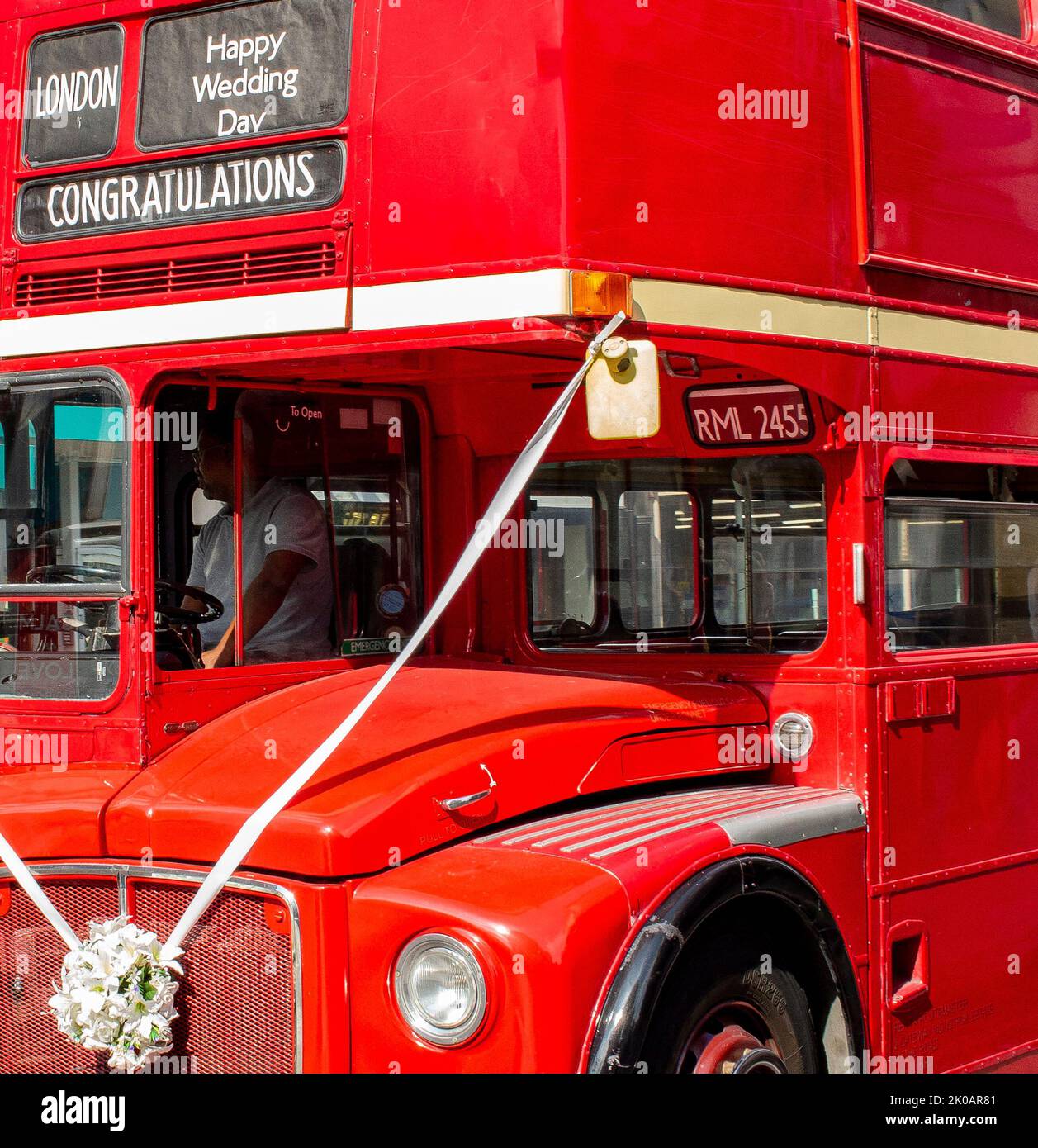 Red London Transport bus acting as private hire for weddings with sash and 'Happy Wedding Day' Stock Photo
