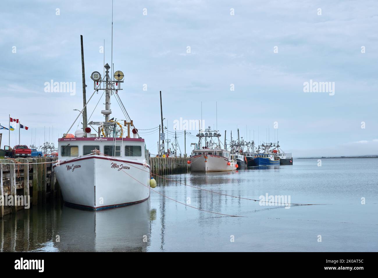 Line of fishing boats lined up along the wharf in Meteghan Nova Scotia. Stock Photo