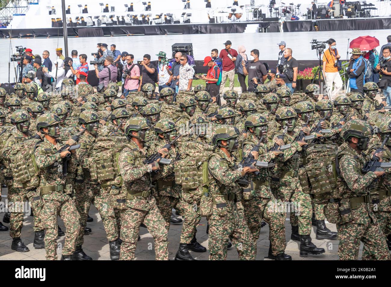 Malaysian Army's troop with camouflage face painted marching with rifles and combat gears during 65th Malaysia National Day parade in Kuala Lumpur. Stock Photo
