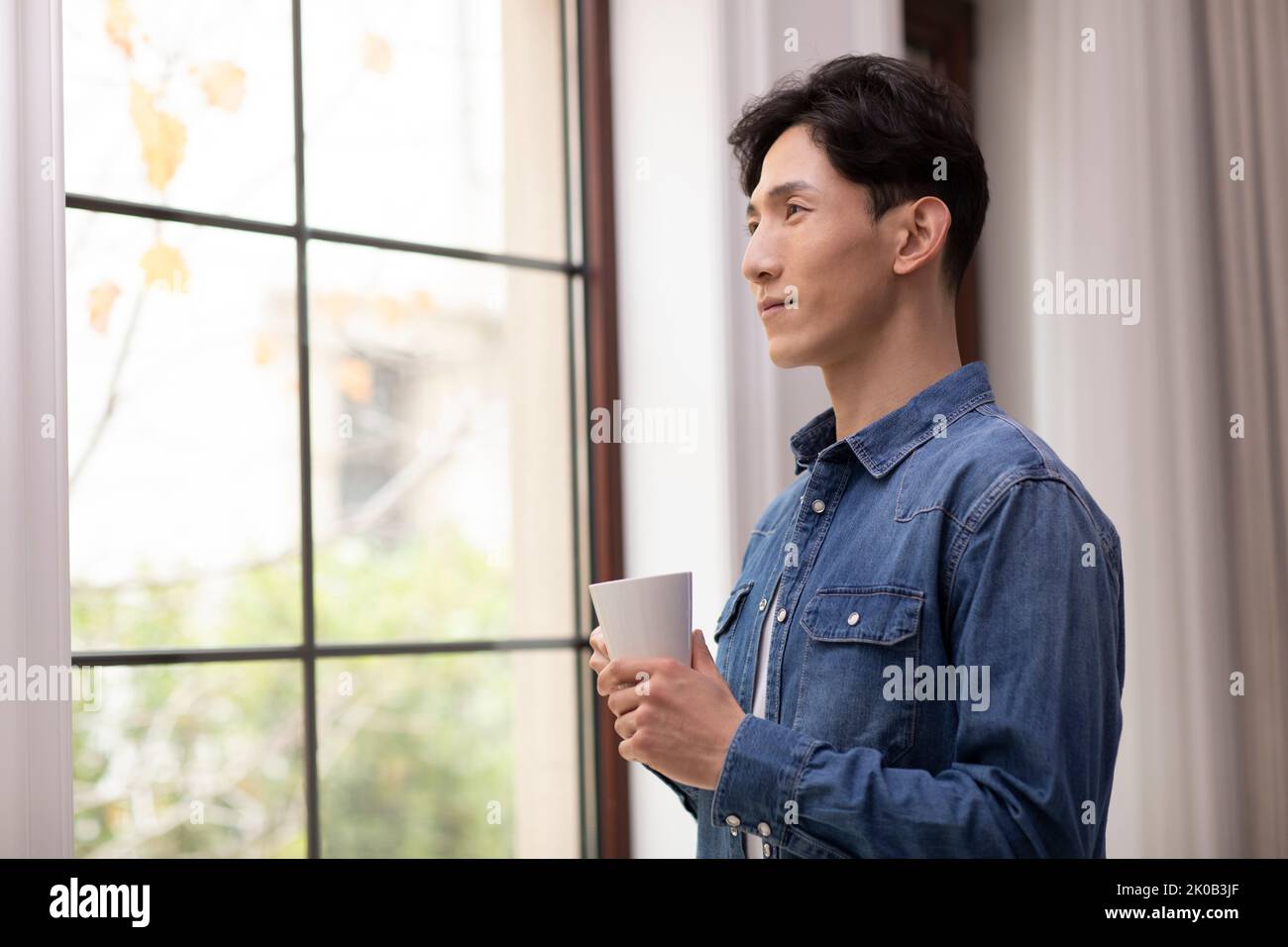 Happy young Chinese man holding coffee Stock Photo