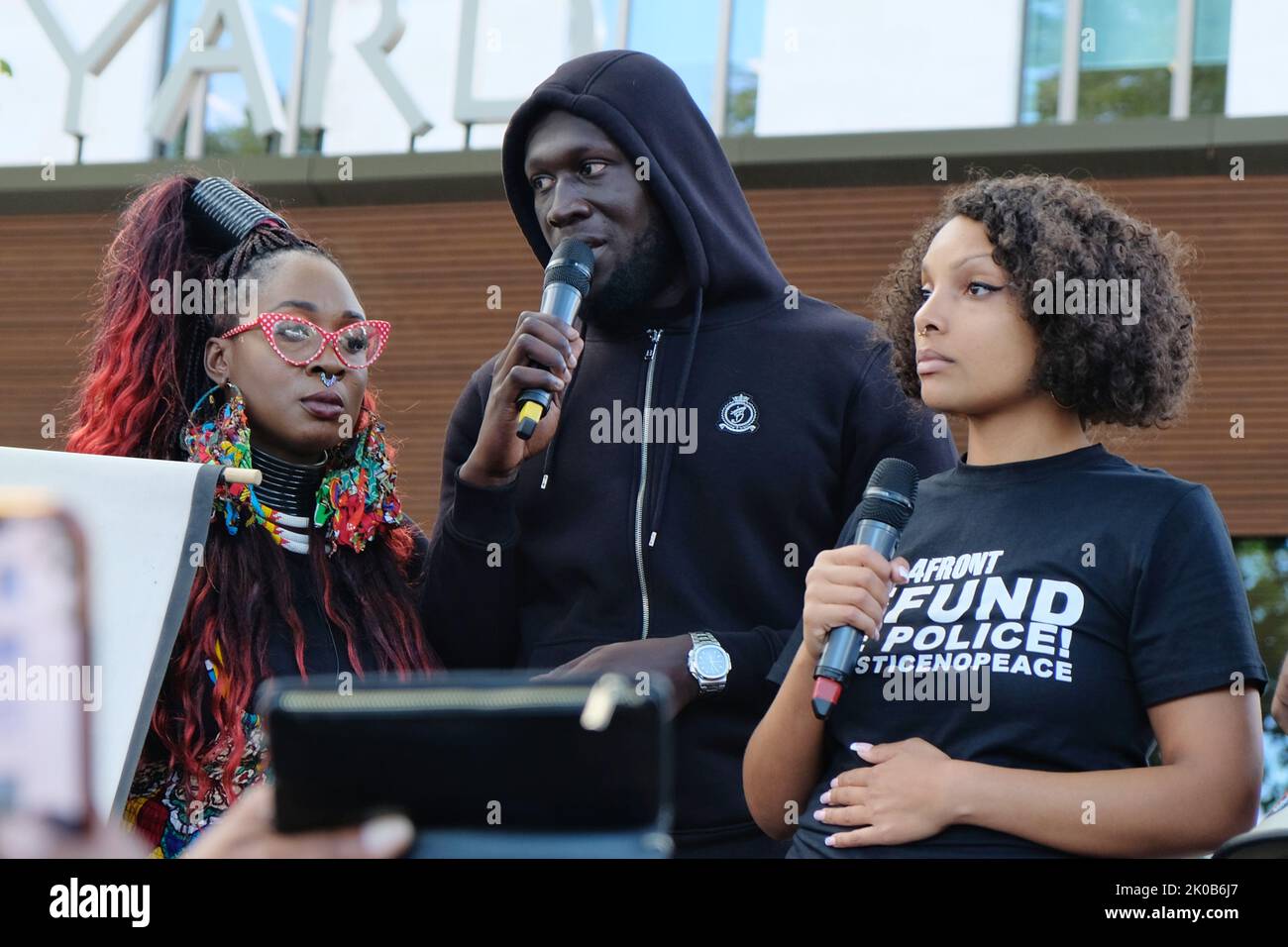 London, UK. 10th September, 2022. Singer Stormzy addresses hundreds of Black Lives Matters protesters outside New Scotland Yard. The demonstrators marched from Parliament Square to the police HQ calling for justice following a fatal shooting of father-to-be Chris Kaba, an unarmed black man, last Monday in sout London by police.  The IOPC are treating the investigation as homicide. Credit: Eleventh Hour Photography/Alamy Live News Stock Photo