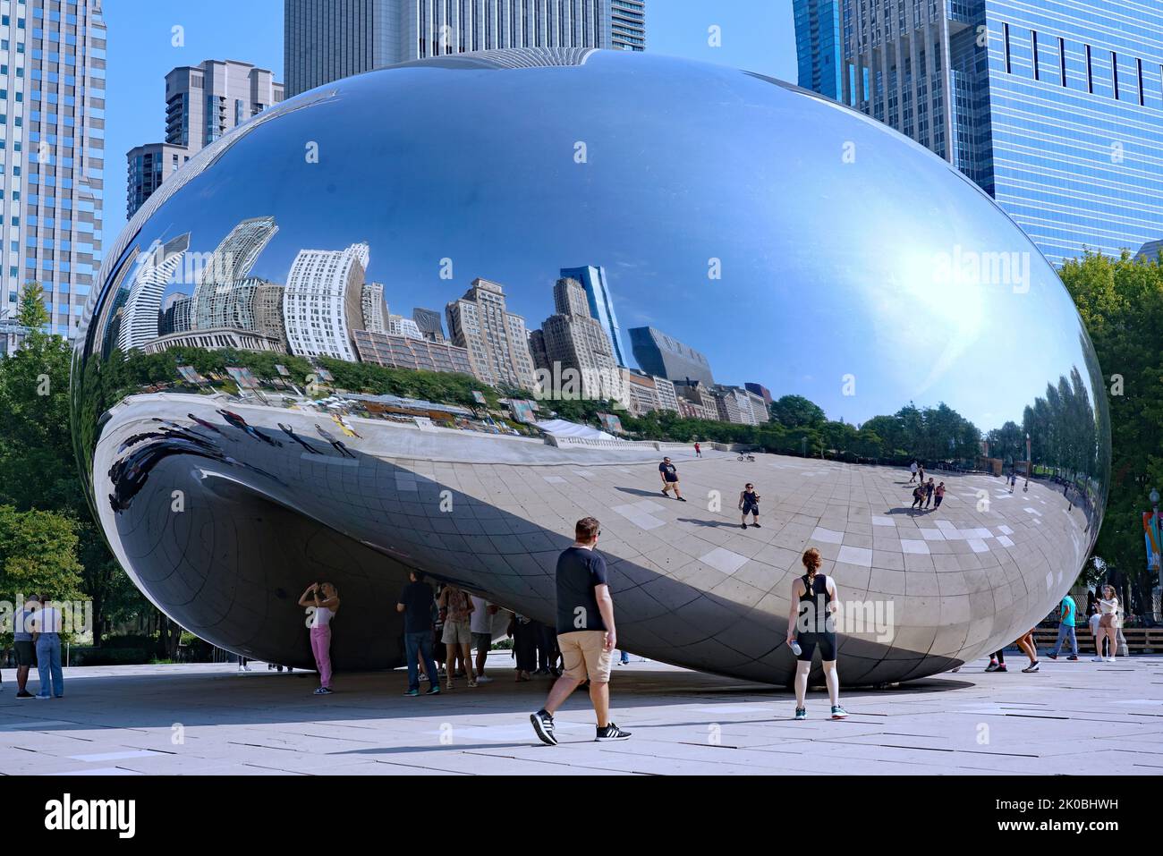 Chicago, USA - August 2022:  Visitors to Milllennium Park enjoying the reflections in the Bean. Stock Photo