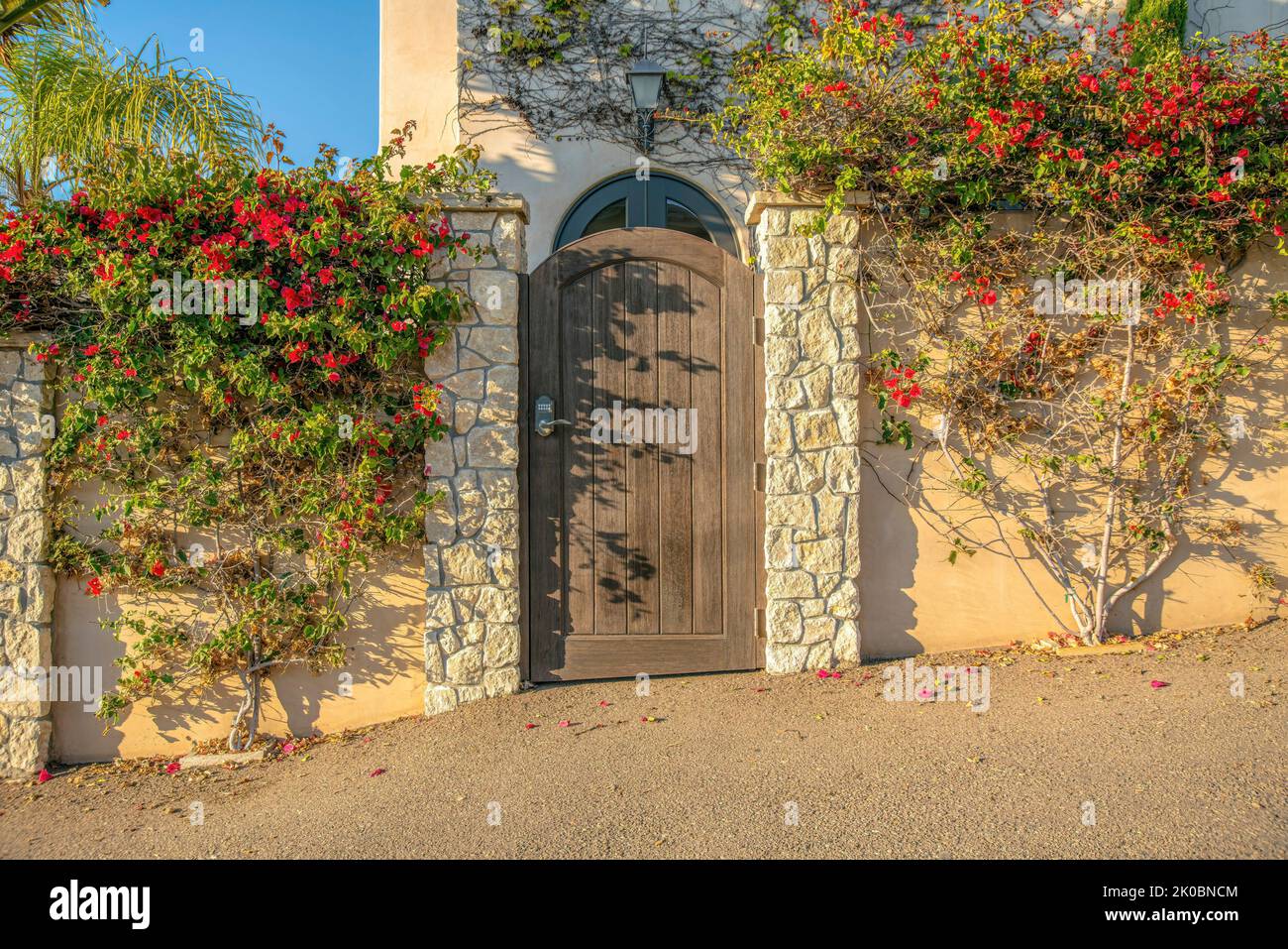La Jolla, California- Wooden gate in between stone pillars and concrete ...