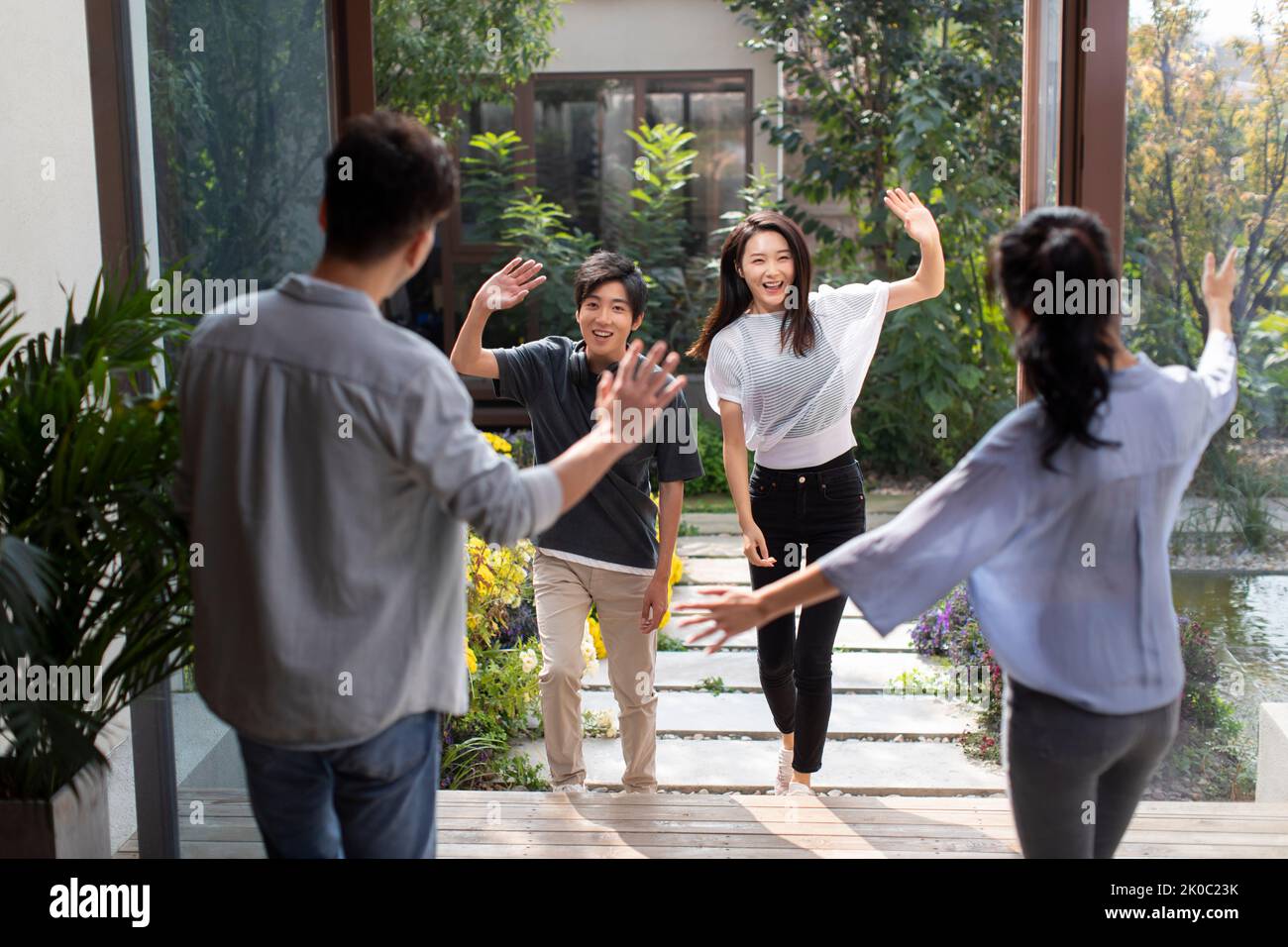 Young Chinese couple welcoming guests for party Stock Photo - Alamy