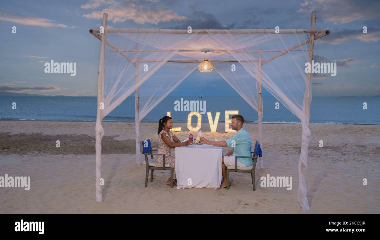 Romantic dinner on the beach of Huahin Thailand, dinner by candlelight in Hua Hin, Valentine's concept. Couple of men and women having a romantic dinner on the beach in Thailand  Stock Photo