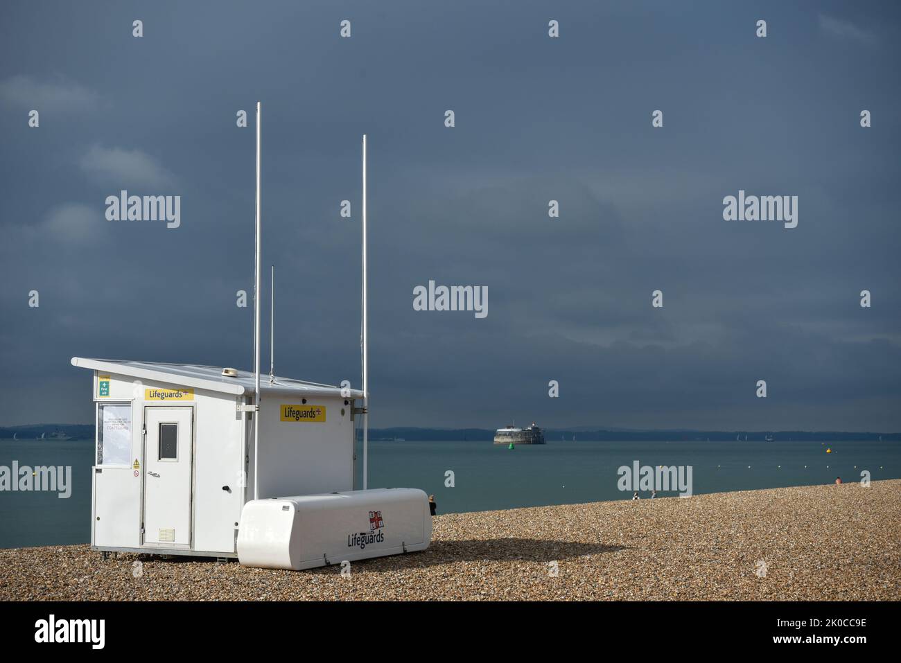 White RNLI hut on Southsea beach in Portsmouth, England on a grey and stormy day. Spitbank fort and the Isle of Wight in the distance. Stock Photo