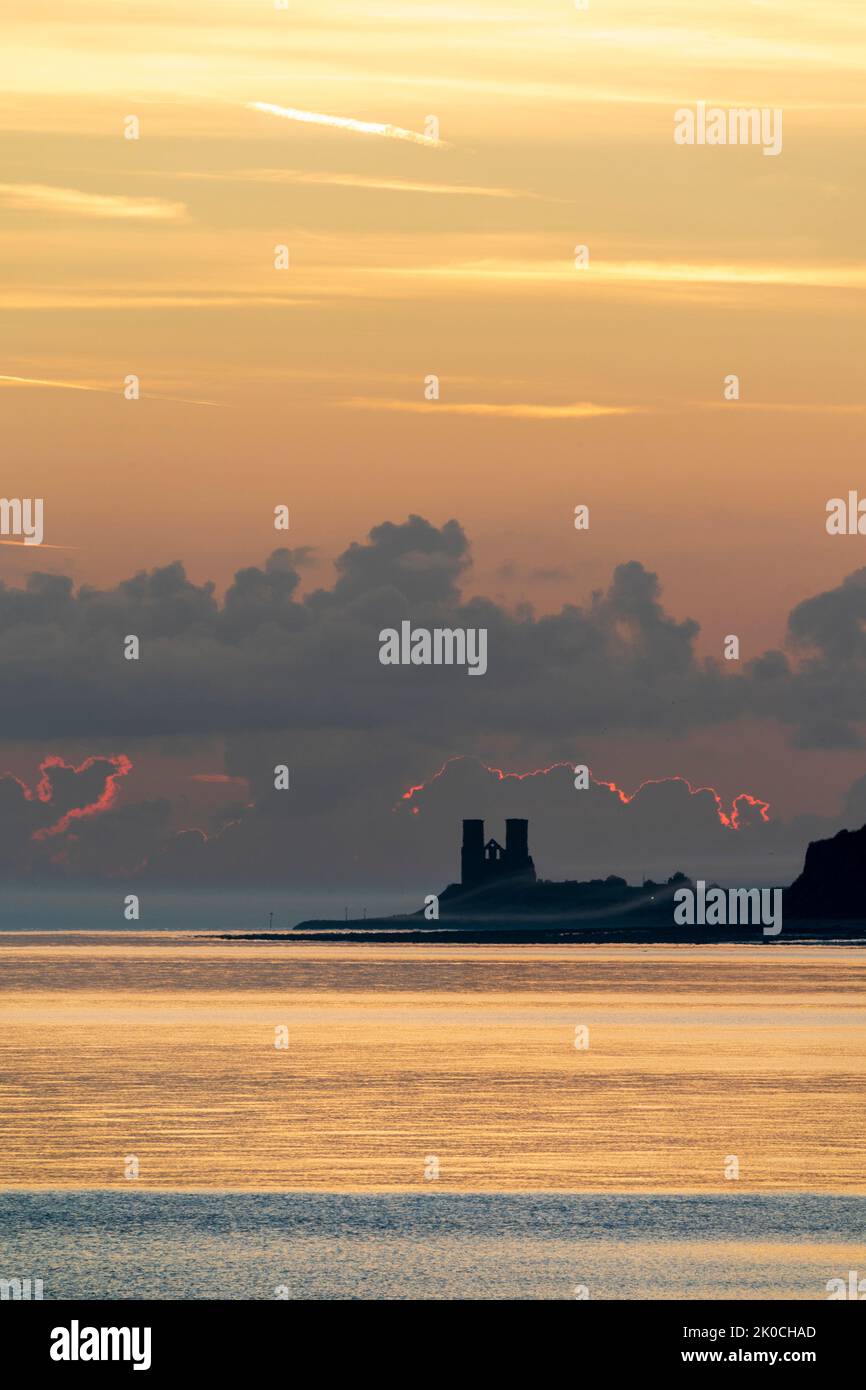Herne Bay, Kent. 11/09/22. The dawn sky breaking over the sea and the landmark Reculver twin towers of the ruined 12th century church, long used as a navigation aid by seafarers. Some ground drifting in over the headland which was quickly dispersed when the sun rose. Credit-Malcolm Fairman, Alamy Live News. Stock Photo