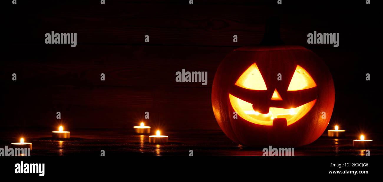 Halloween Jack O Lantern pumpkin and burning candles traditional decoration Stock Photo