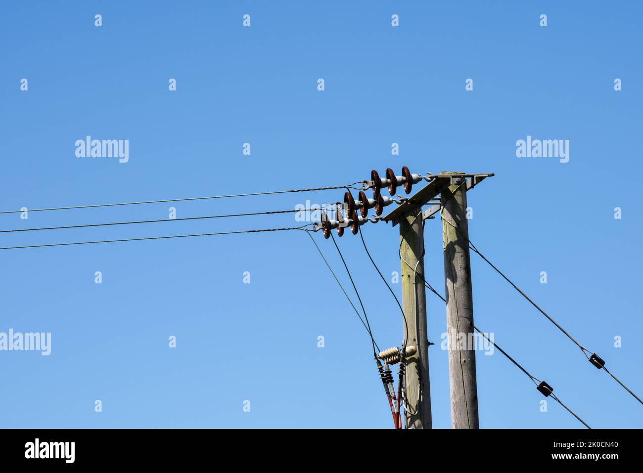 Power lines on blue sky background Stock Photo
