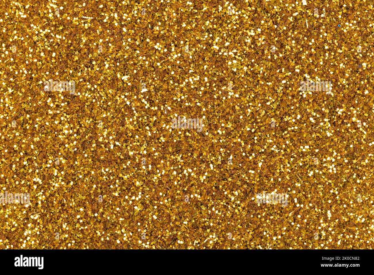 Elegant gold glitter texture, background with attractive shiny surface for design. Sparkling shiny wrapping paper, New Year holiday seasonal wallpaper Stock Photo