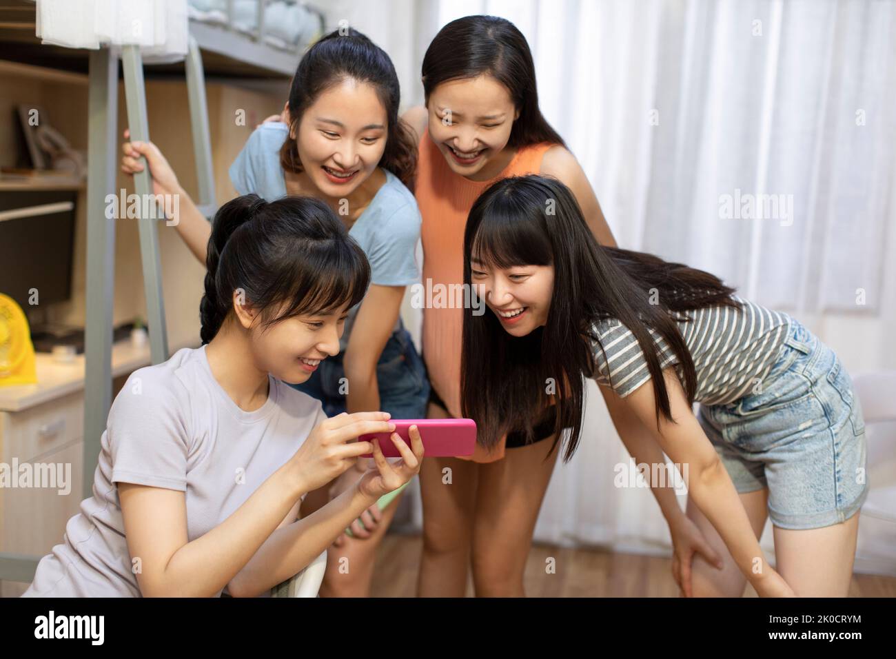 Young Chinese university students using smart phone in dormitory Stock Photo