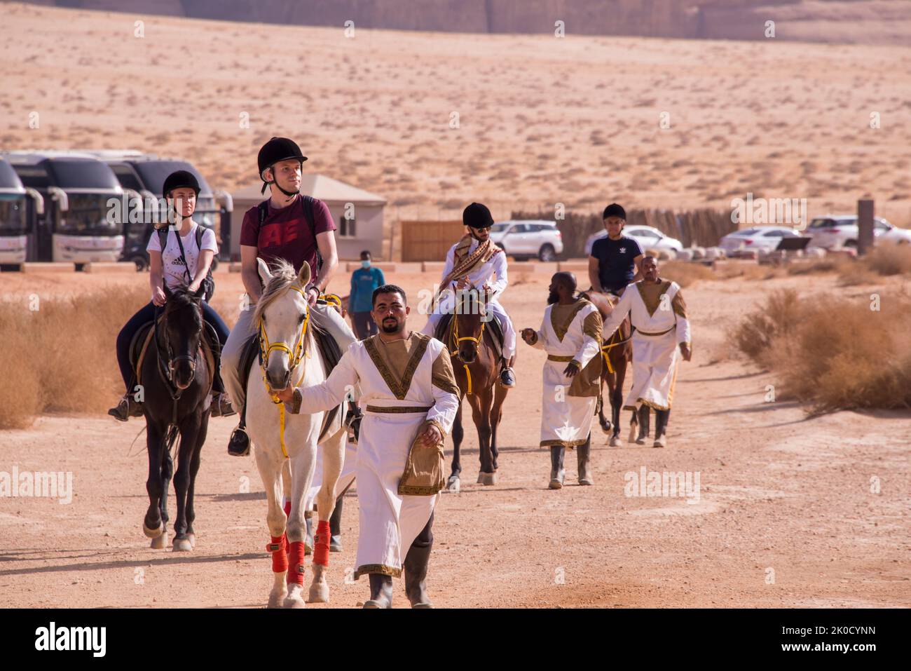 Tourists on horseback being led by handlers Hegra Saudi Arabia Stock Photo