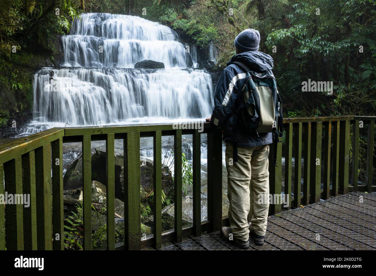 Tourist looking at cascading  Purakaunui Falls, Catlins, South Island. Stock Photo