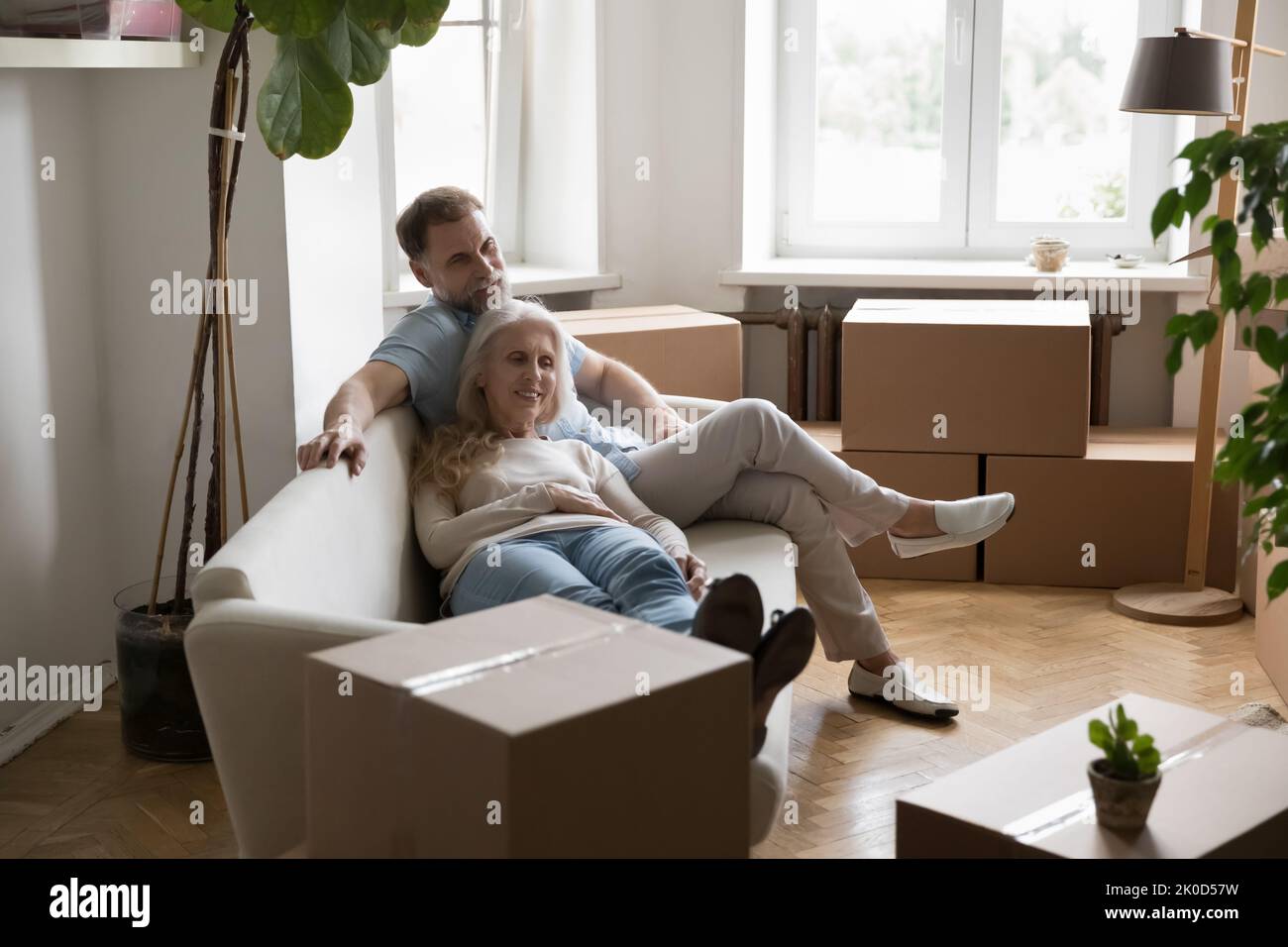 Older senior couple of new landlords, homeowners resting on sofa Stock Photo