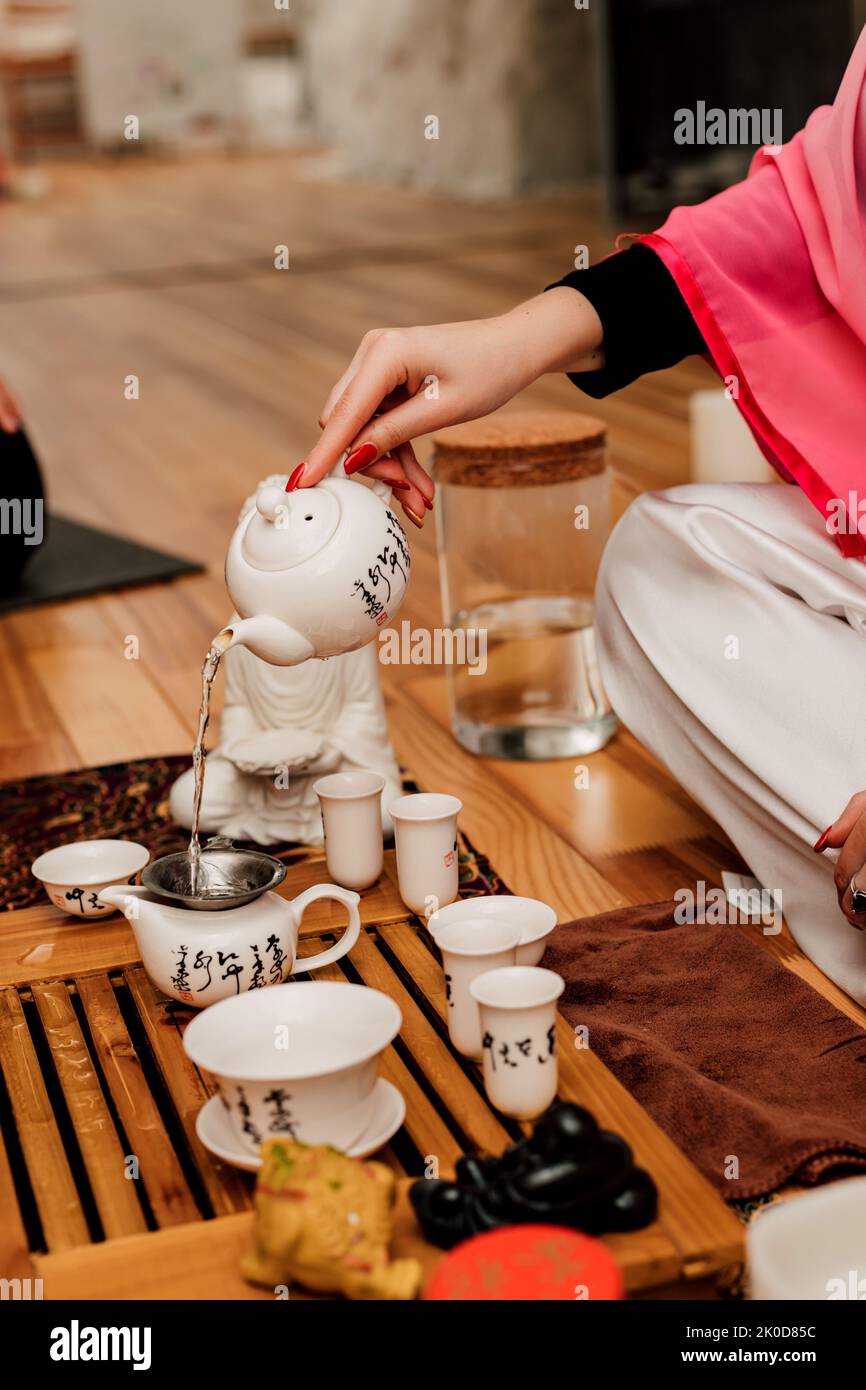 Chinese tea ceremony. A girl pours tea into cups Stock Photo
